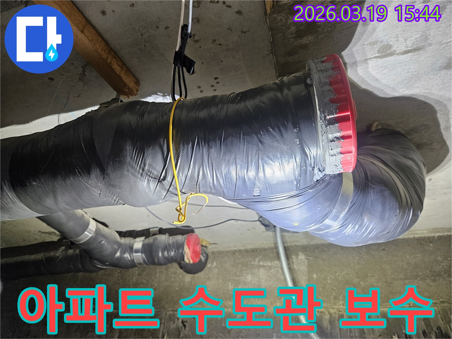 천장에 설치된 검은색 단열재로 감싸진 굵은 배관과-그 옆으로 연결된 회색 파이프들이 보입니다
