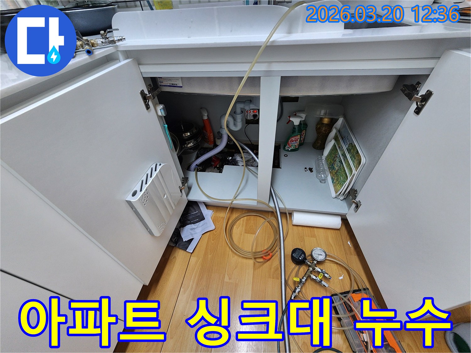 아파트 싱크대 아래에서-누수 지점을-정확히 찾기 위해-탐지 장비를-설치하고-점검하는-모습입니다.