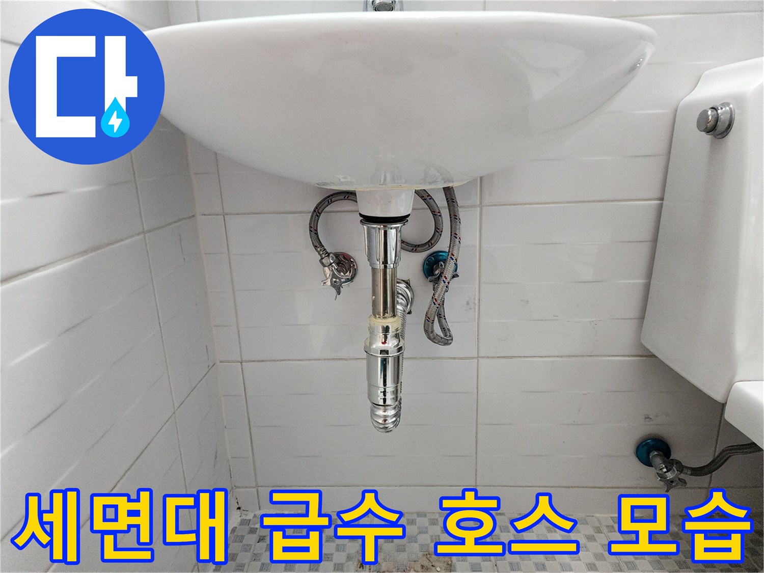 세면대 아래쪽으로 연결된 은색 유연한 배관 호스