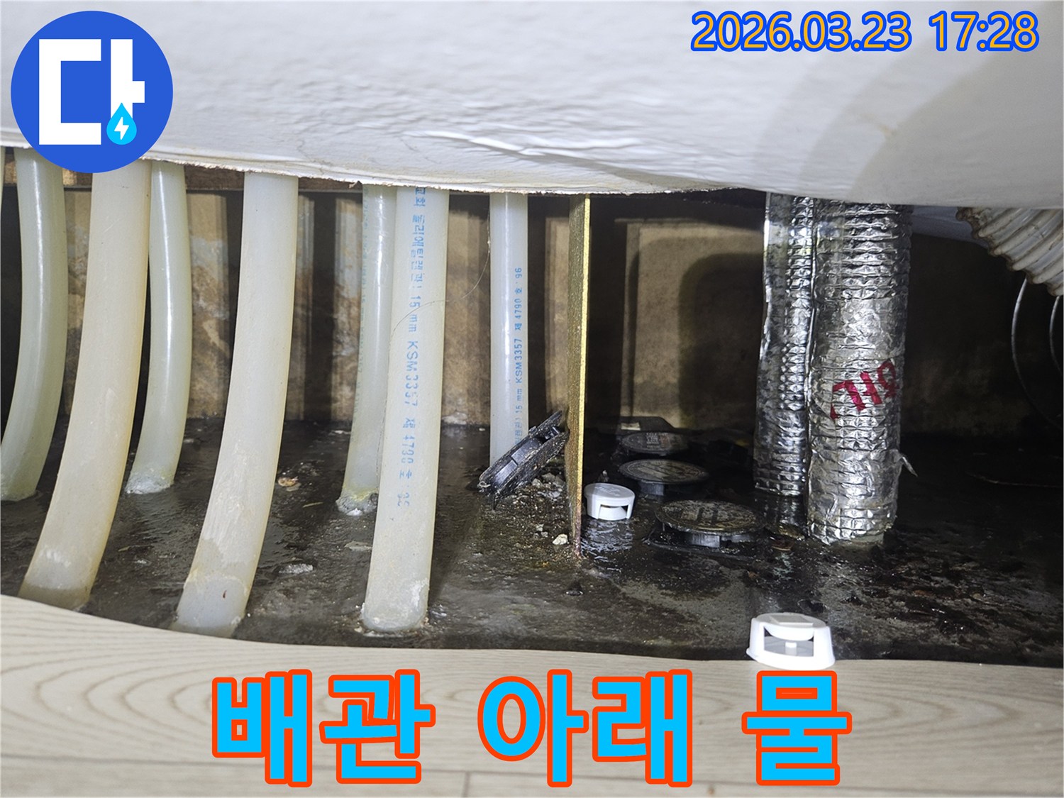 배관 아래에-물이 고여있는-누수 현장의-심각성을 보여주는-현장 사진입니다.