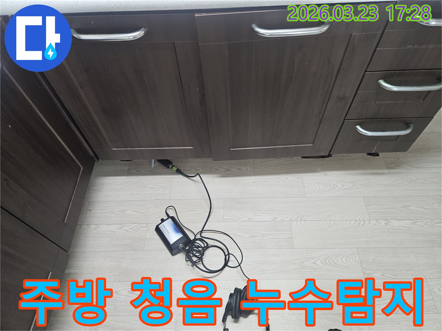주방 싱크대 하부에서-누수를 찾기 위해-청음식 탐지 장비로-정밀하게 검사하는 모습