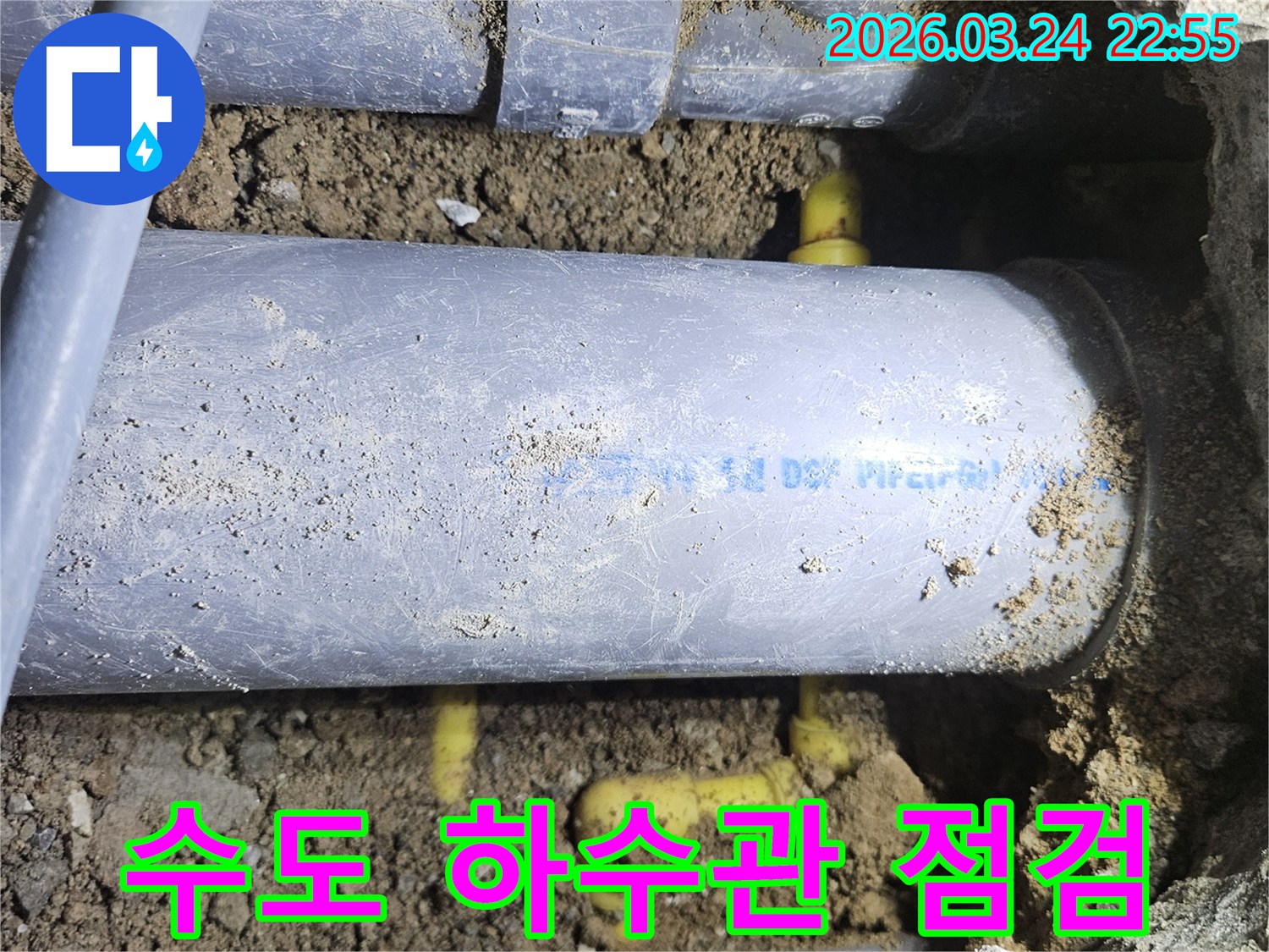 누수 지점을 찾기 위해-땅을 파헤쳐 드러난-수도관과 하수관을-전문가가 확인하는 모습