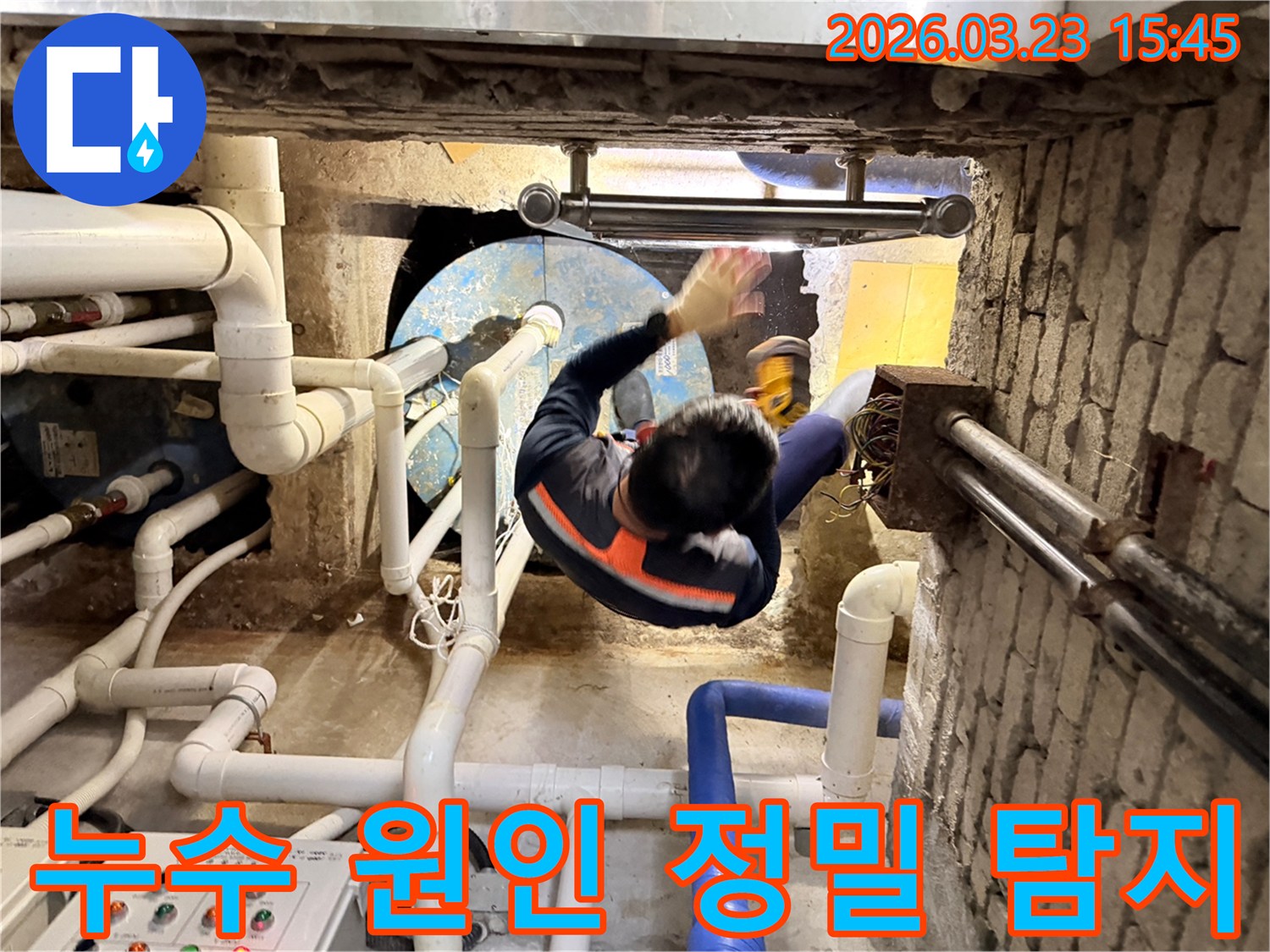 누수 전문가가 좁고 어두운 공간에서 배관 상태를 꼼꼼히 확인하며 누수 지점을 찾는 모습
