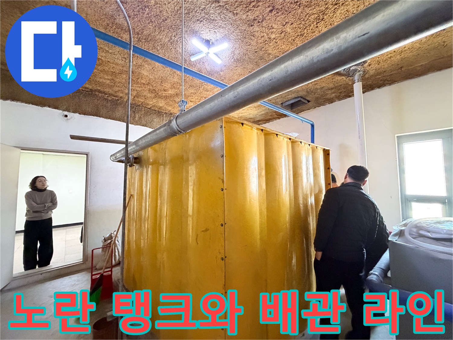 지하 공간의 노란색 탱크-천장에 연결된 금속 관로 구조물
