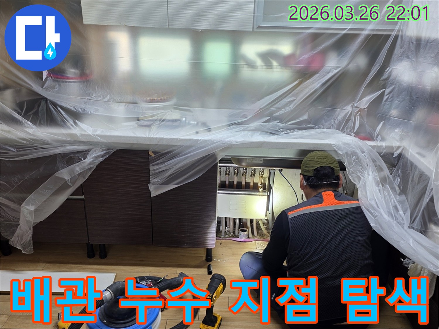 누수 엔지니어가-주방 하부장 아래-보일러 분배기 주변의-배관 연결부를-집중적으로-검사하고 있습니다.