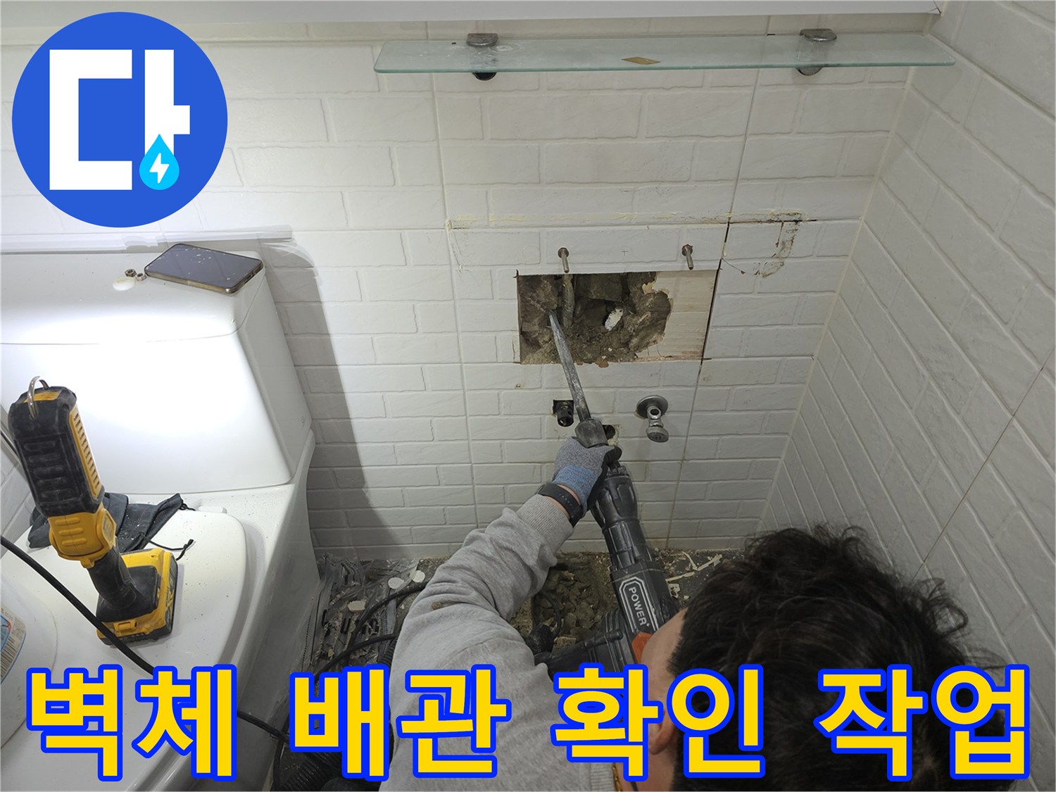 매립된 온수 배관의 손상 부위를 찾기 위해 벽면을 파헤치는 작업 모습입니다.