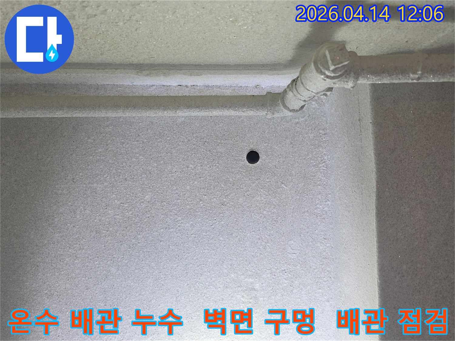 갈현동 현대아파트에서-온수 배관 누수를 진단하기 위해-벽에 뚫은 작은 구멍과-주변 배관을 보여줍니다