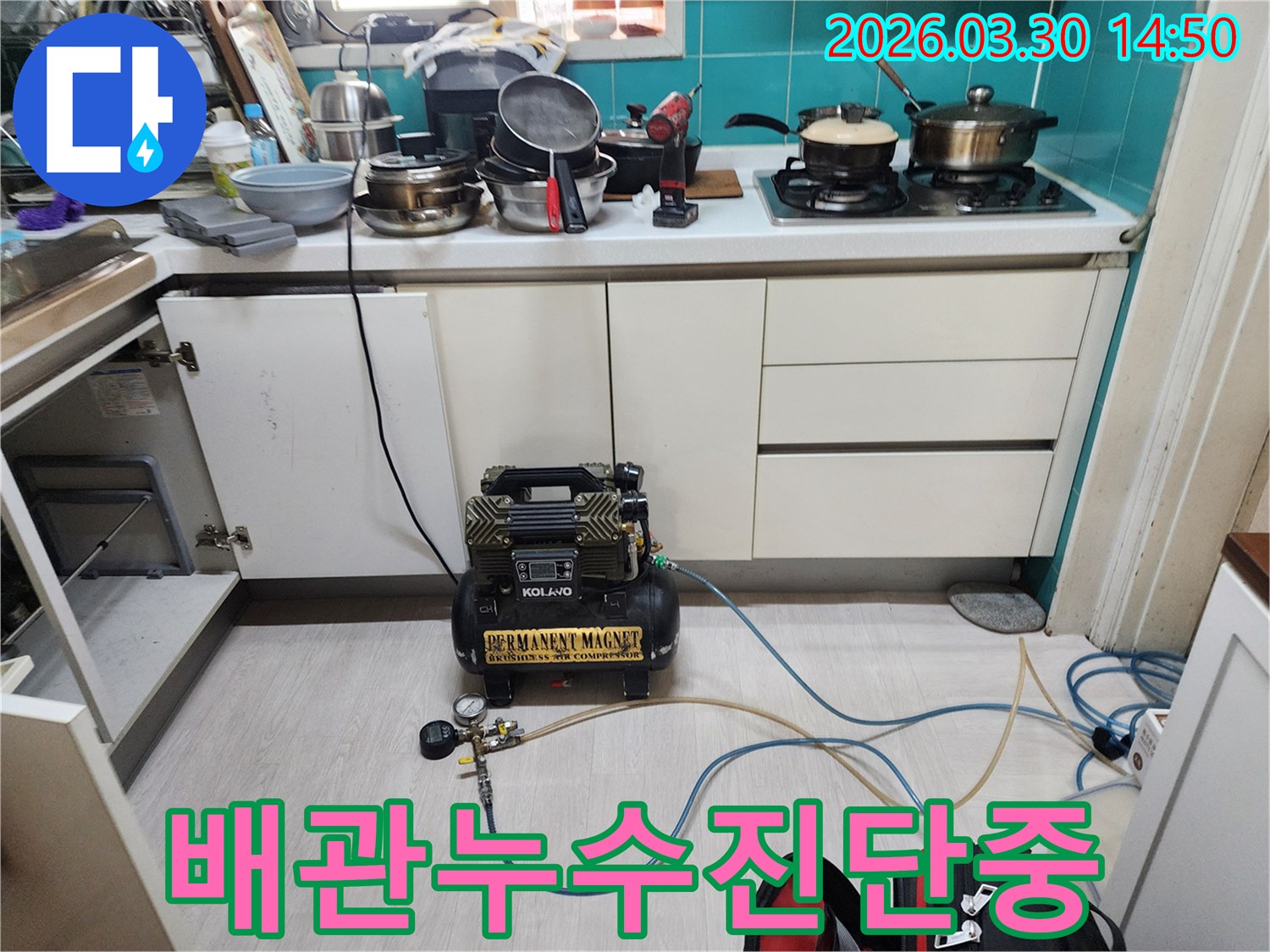 주방 싱크대 하부에서-배관 누수 여부를 확인하기 위해-공압 장비가 연결되어-압력 검사를 진행하고 있습니다.