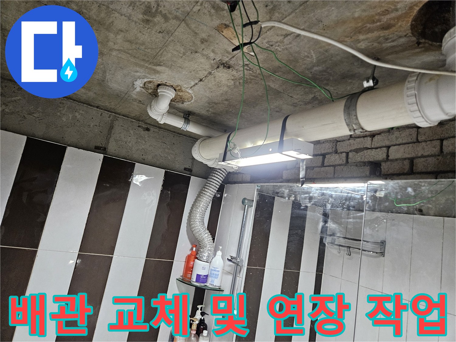 화장실 천장 하부의 노후된 배관을 새 제품으로 교체하여 연결한 모습