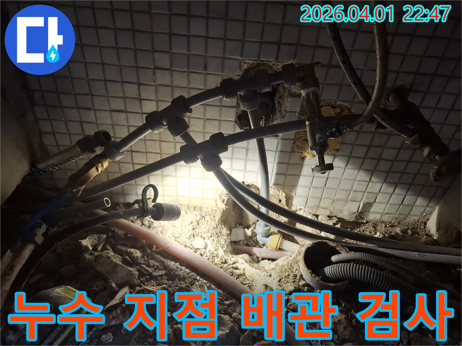 어두운 틈새에서-누수 지점을 밝혀내기 위해-배관을 정밀하게 검사하는 모습