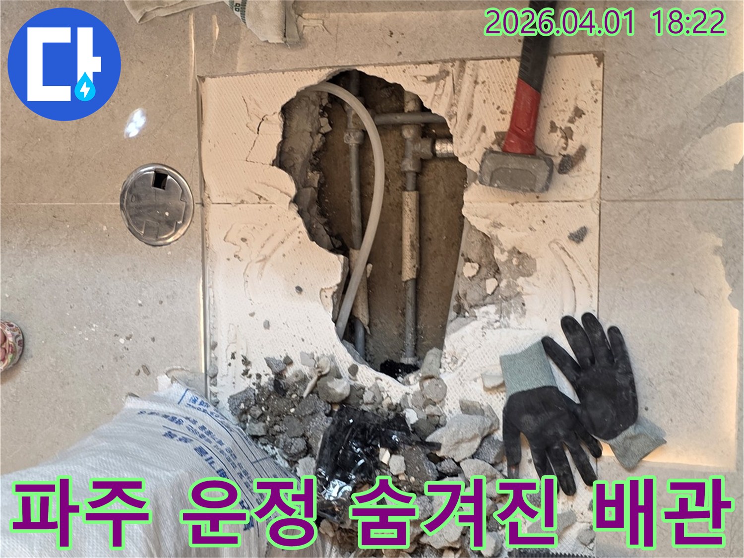 운정 아파트 누수 공사 중-바닥을 파쇄하여-누수 지점의 배관을 노출시키는 장면
