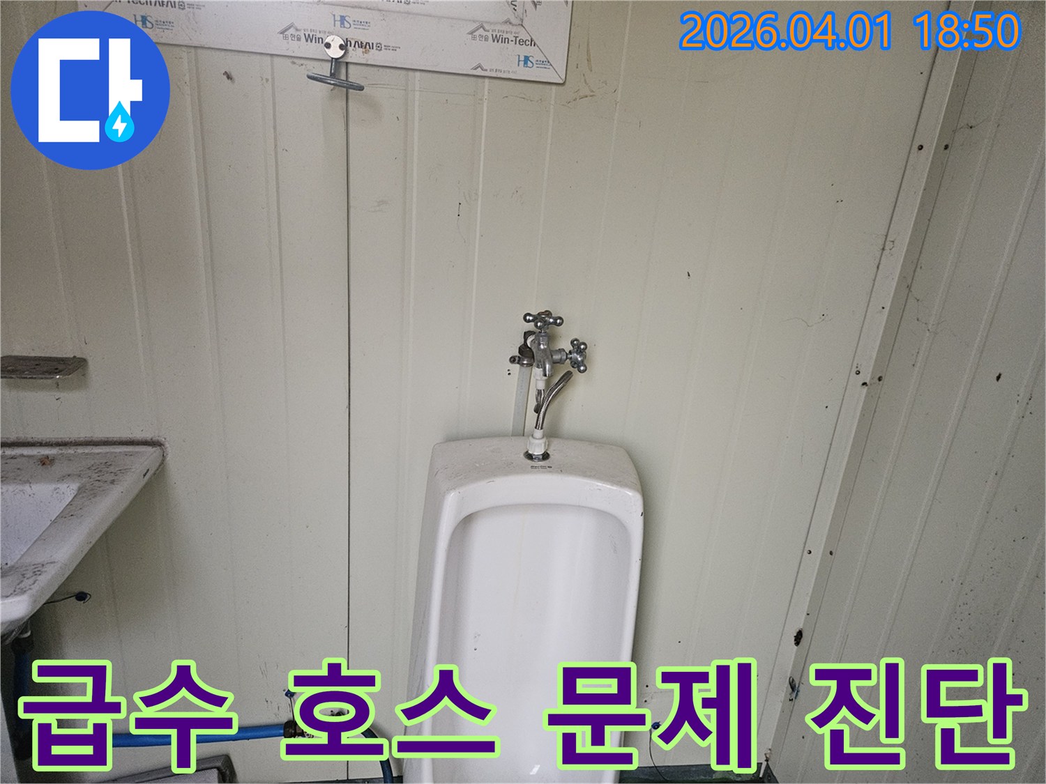 가설 화장실 소변기 하단에 연결된-파란색 급수 호스에서-누수가 의심되어-정밀하게 진단하는 과정을 담은 사진