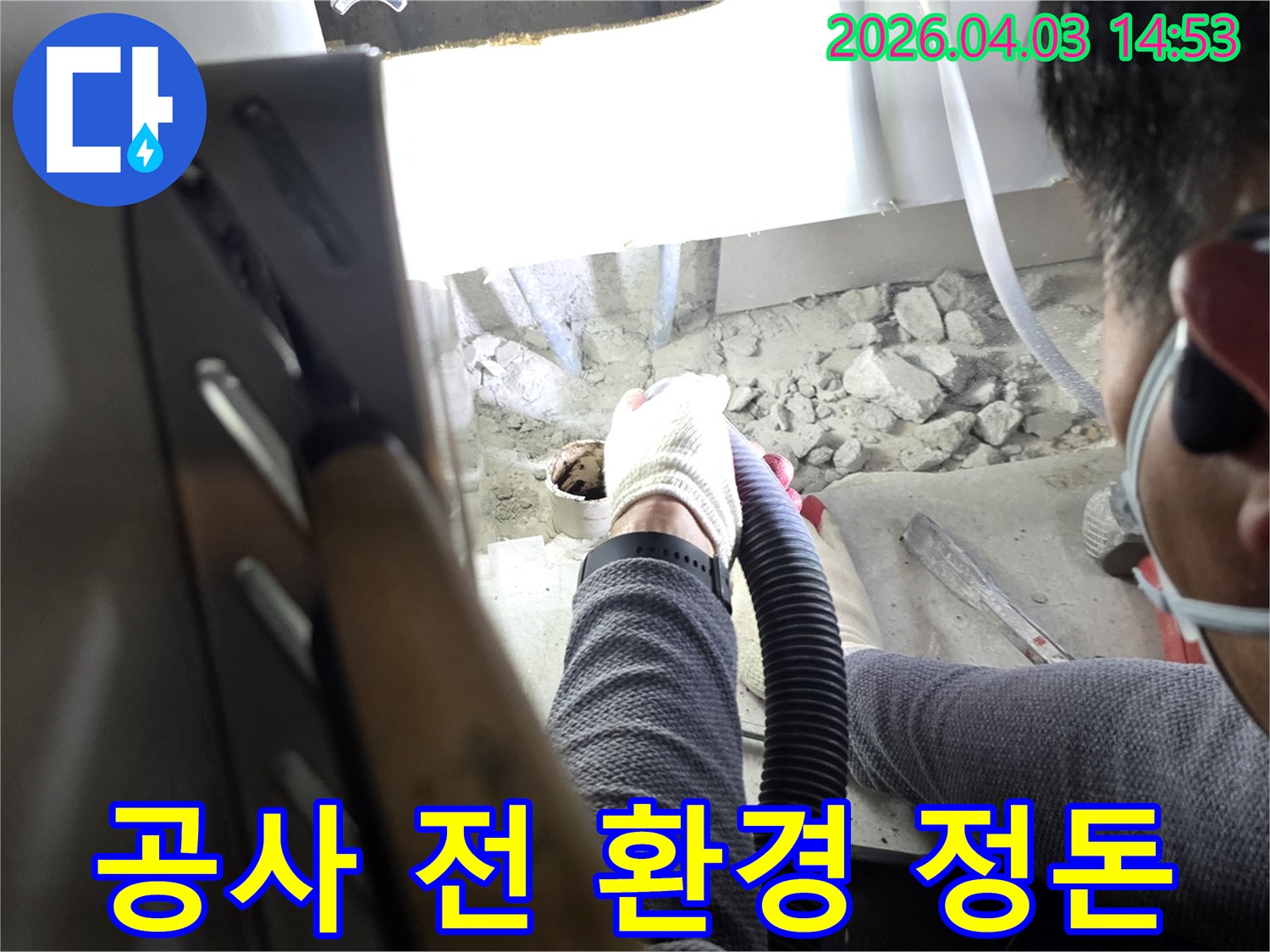 누수공사 시작 전-작업자가 흡입기로 작업 환경을 정돈하는 모습