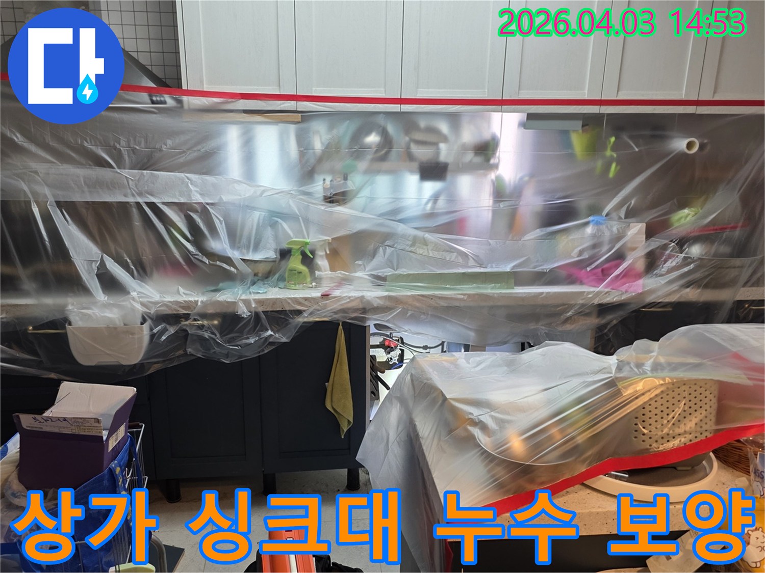 이 사진은 운정 상가 주방 싱크대 배관 교체 작업을 시작하기 전-주변 가구와 공간을 비닐로 안전하게 보호하는-보양 작업이 완료된 상태를 보여줍니다.