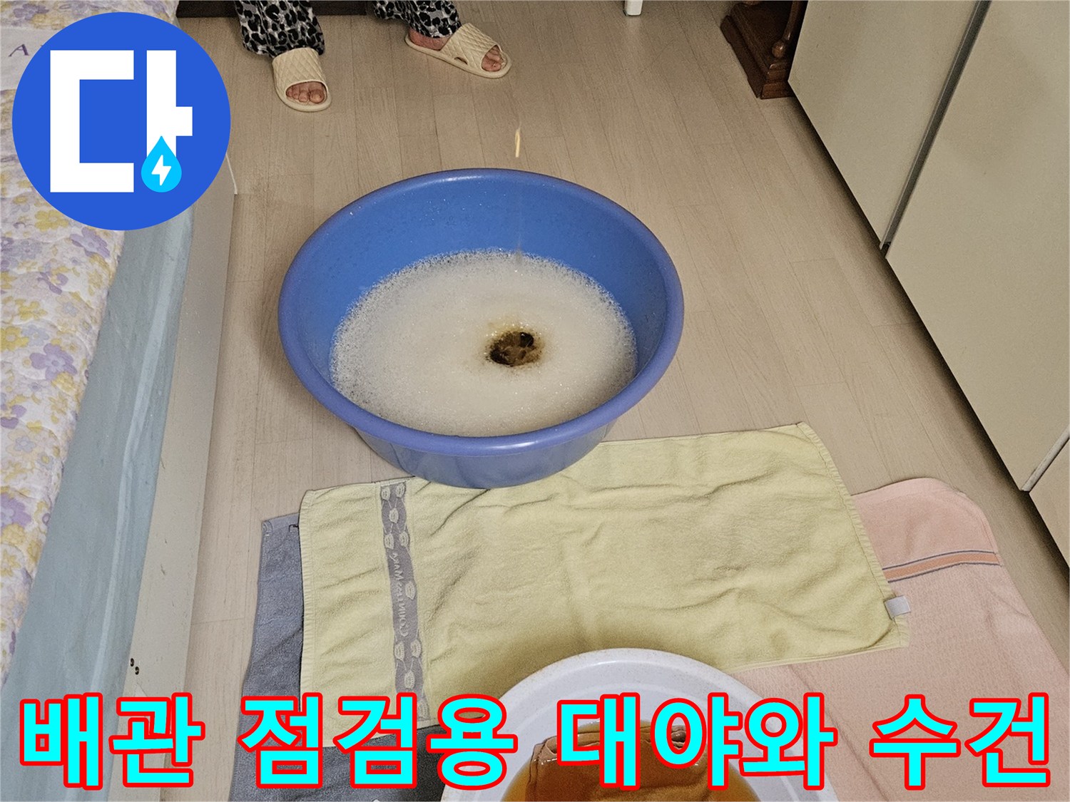 누수 진단을 위해 준비된 배관 점검용 대야와 마른 수건