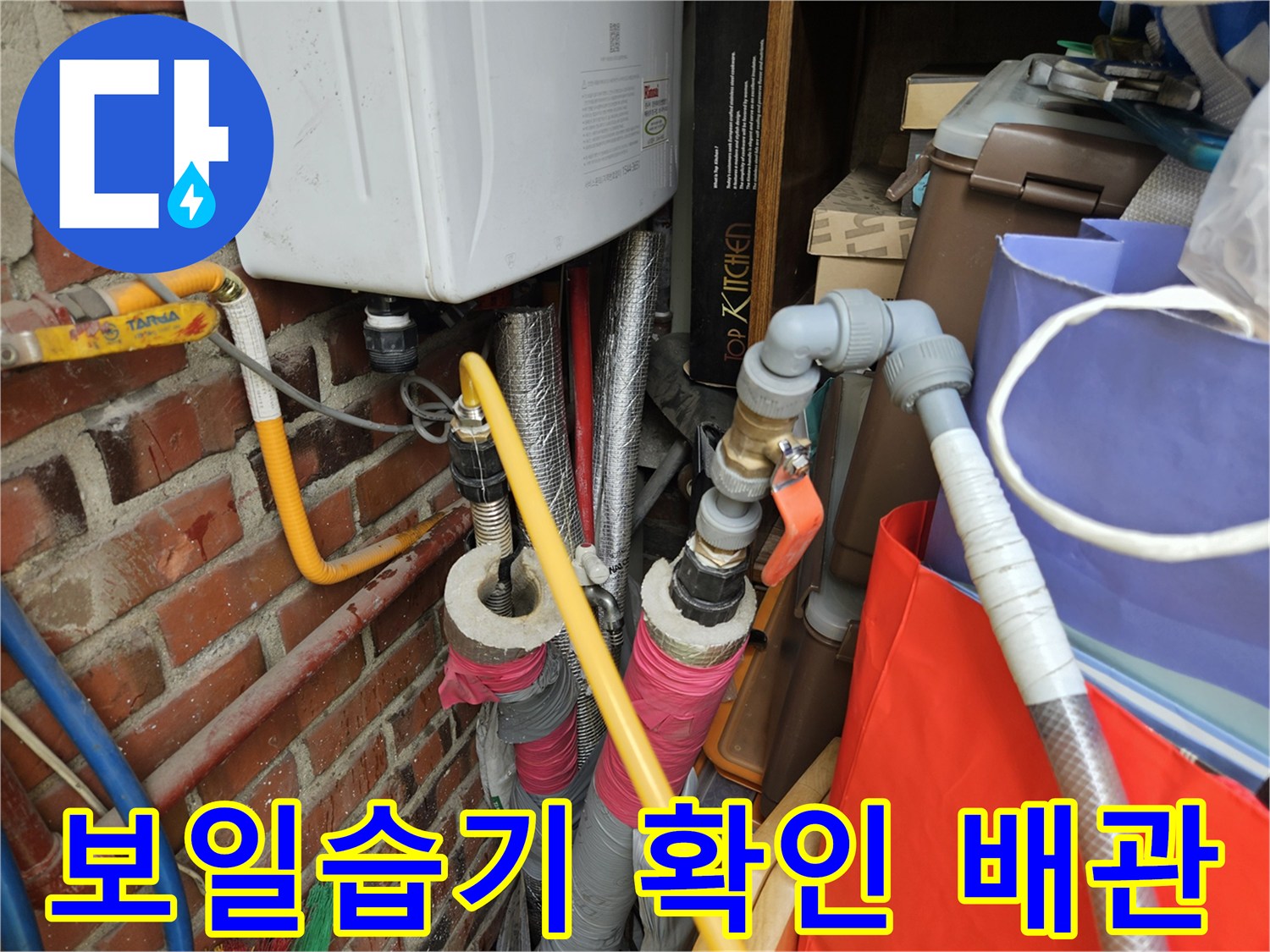 벽돌 벽면 근처에 노출된 보일러 배관 및 밸브 상세 사진