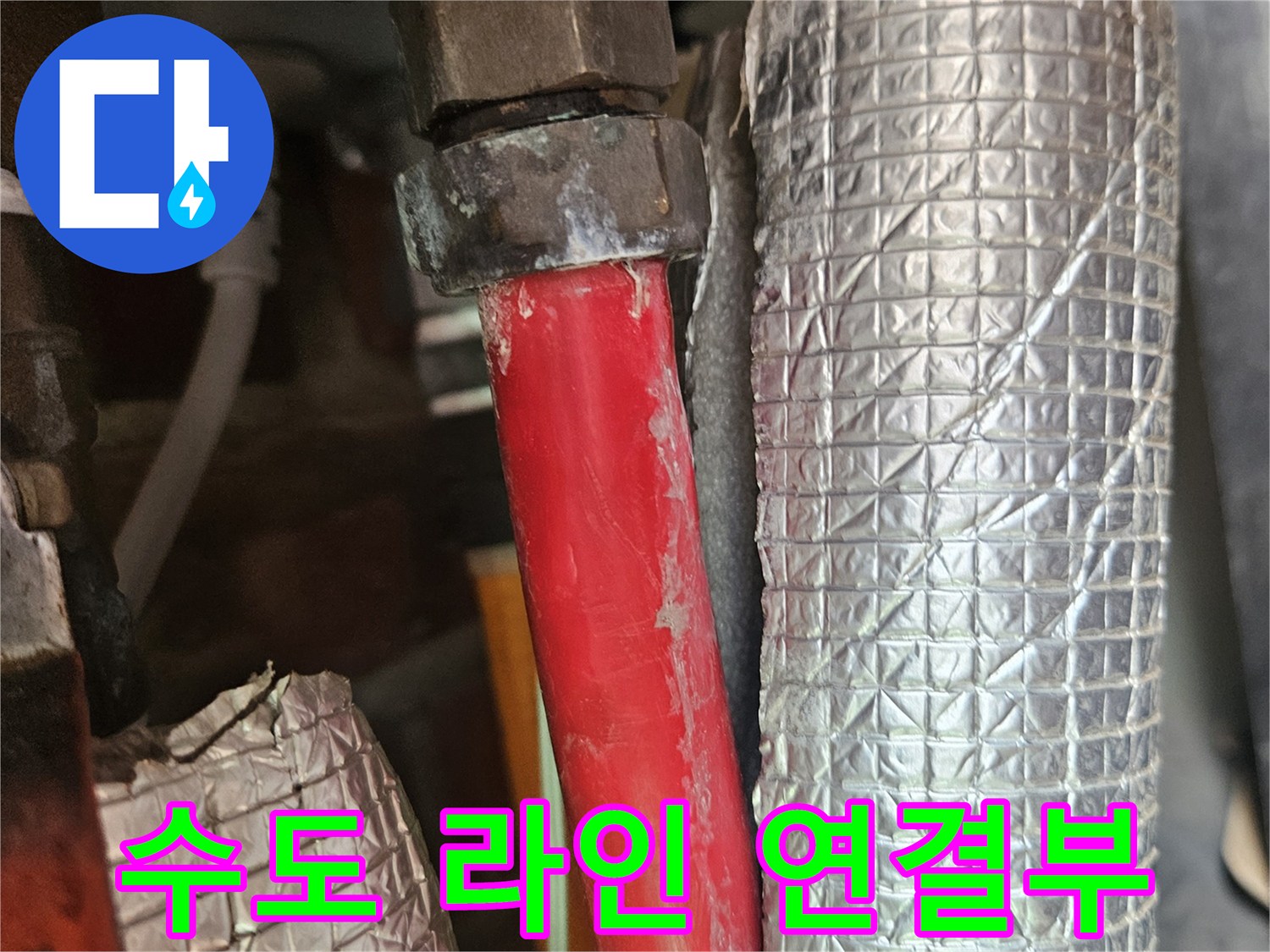보온재로 덮인 배관과 노출된 붉은색 배관의 접합 지점 상세 촬영
