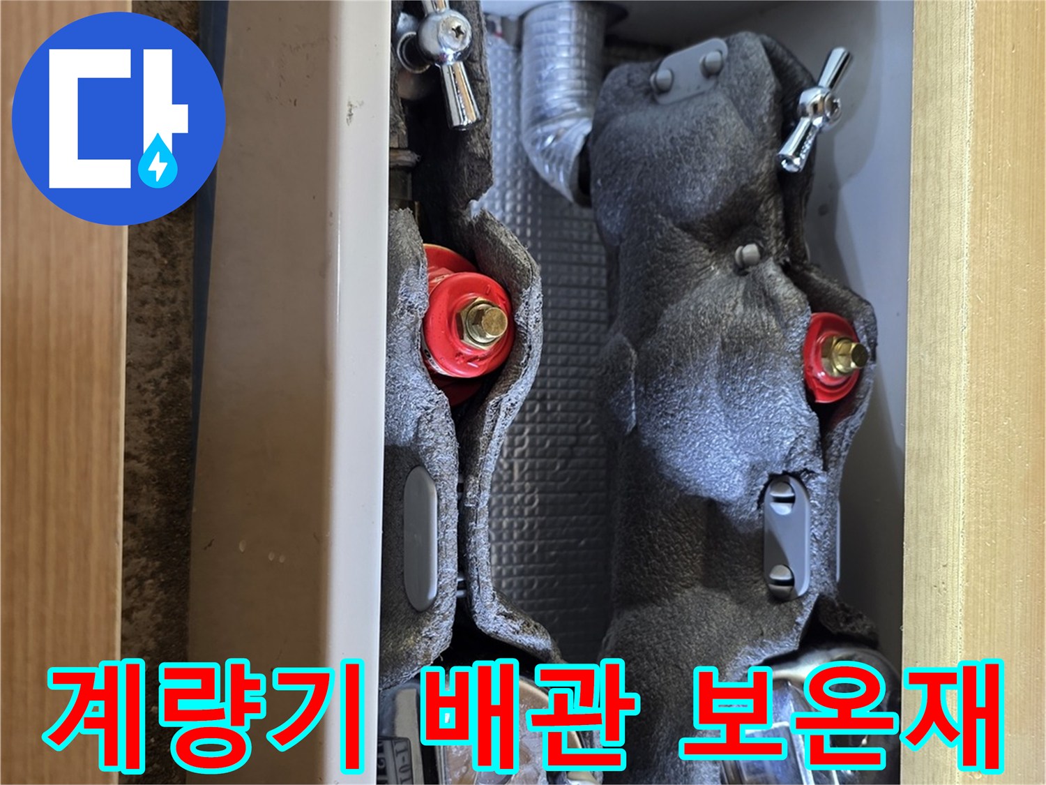 두꺼운 보온재로 덮여 있는 수도 계량기함 내부의 배관 모습입니다.