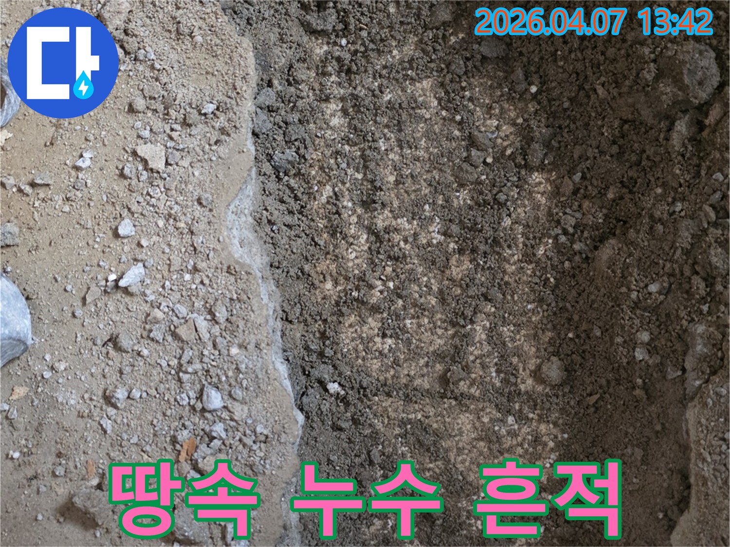 누수-탐지-현장에서-땅을-파내어-드러난-배관-주변의-습기-머금은-흙을-보여주는-이미지