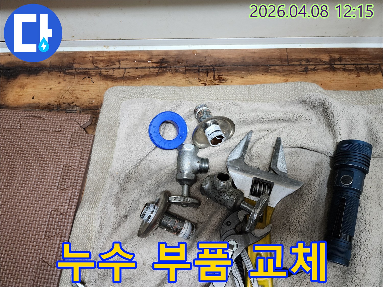 누수 부품 교체 작업을 위해-준비된 새 부품들과-다양한 전문 공구들이-수건 위에 놓여 있습니다