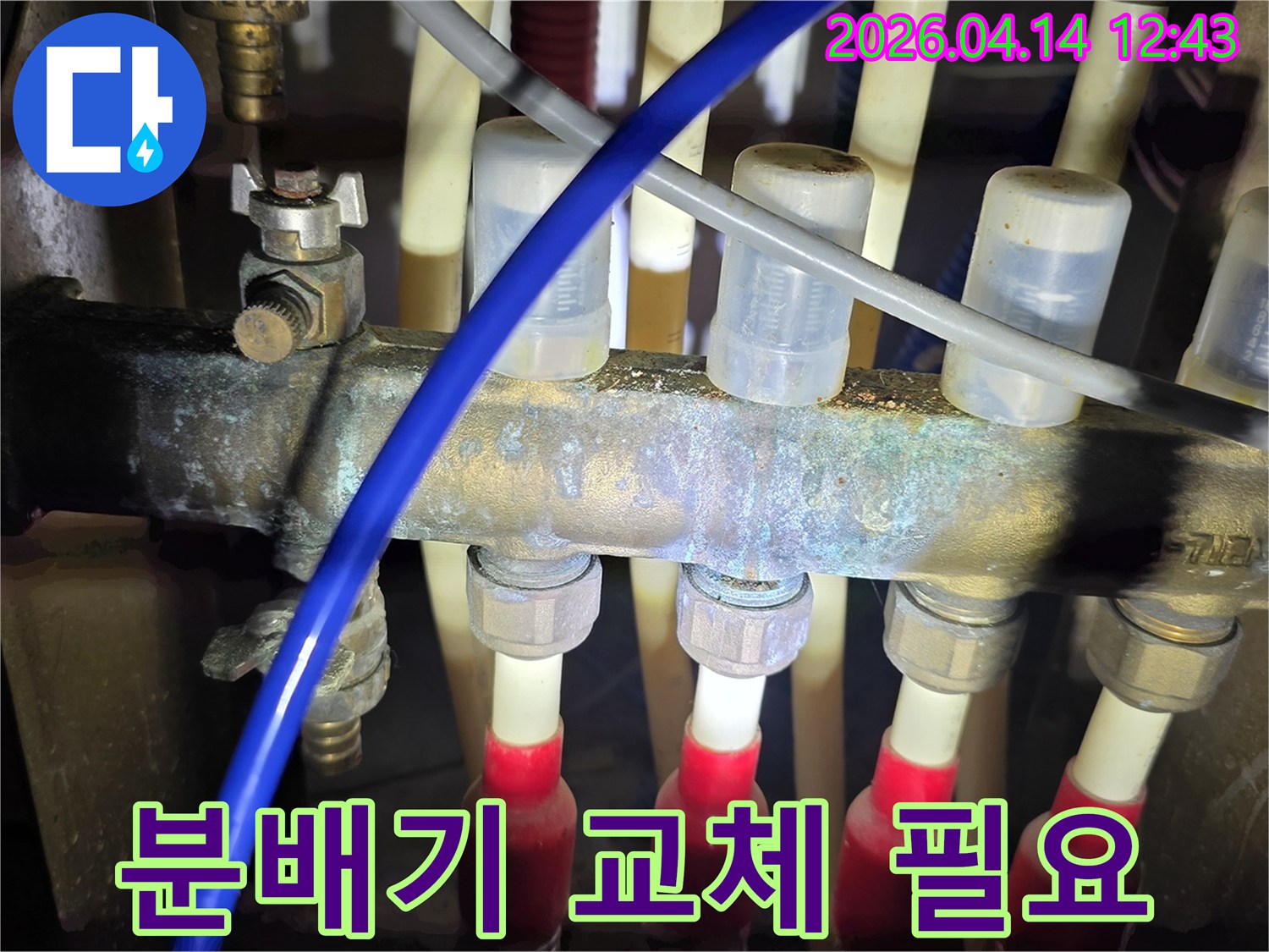 심하게 부식된 난방 분배기로-인해-누수가 발생하는-현장을-보여주는-사진입니다.