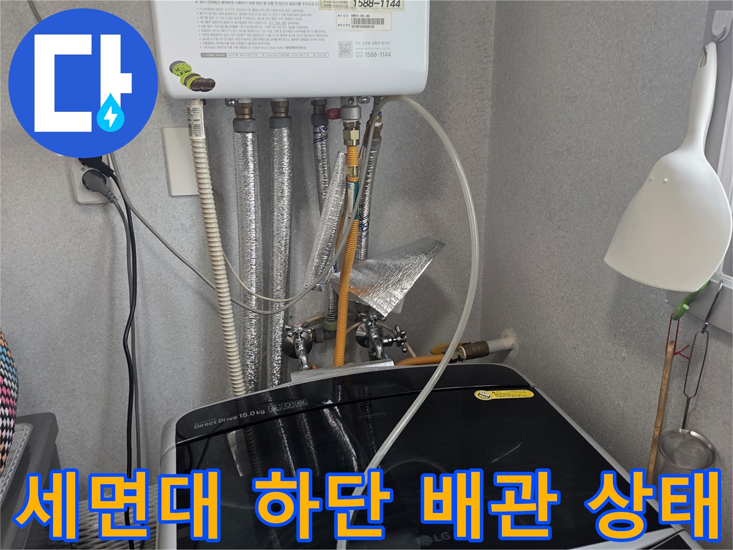 세면대 아래쪽 보조 배관과 온수기 연결 부위 모습