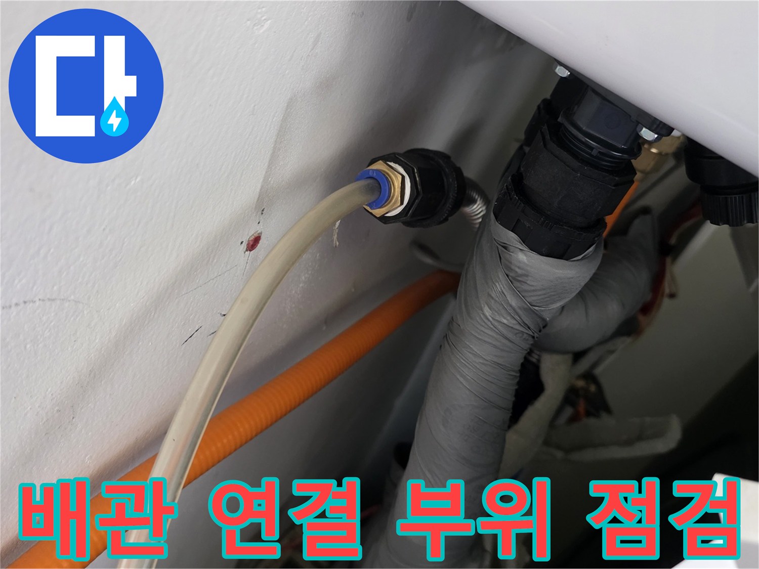 화장실 배수관과 하얀색 벽면의 연결 부위를 근접 촬영한 사진
