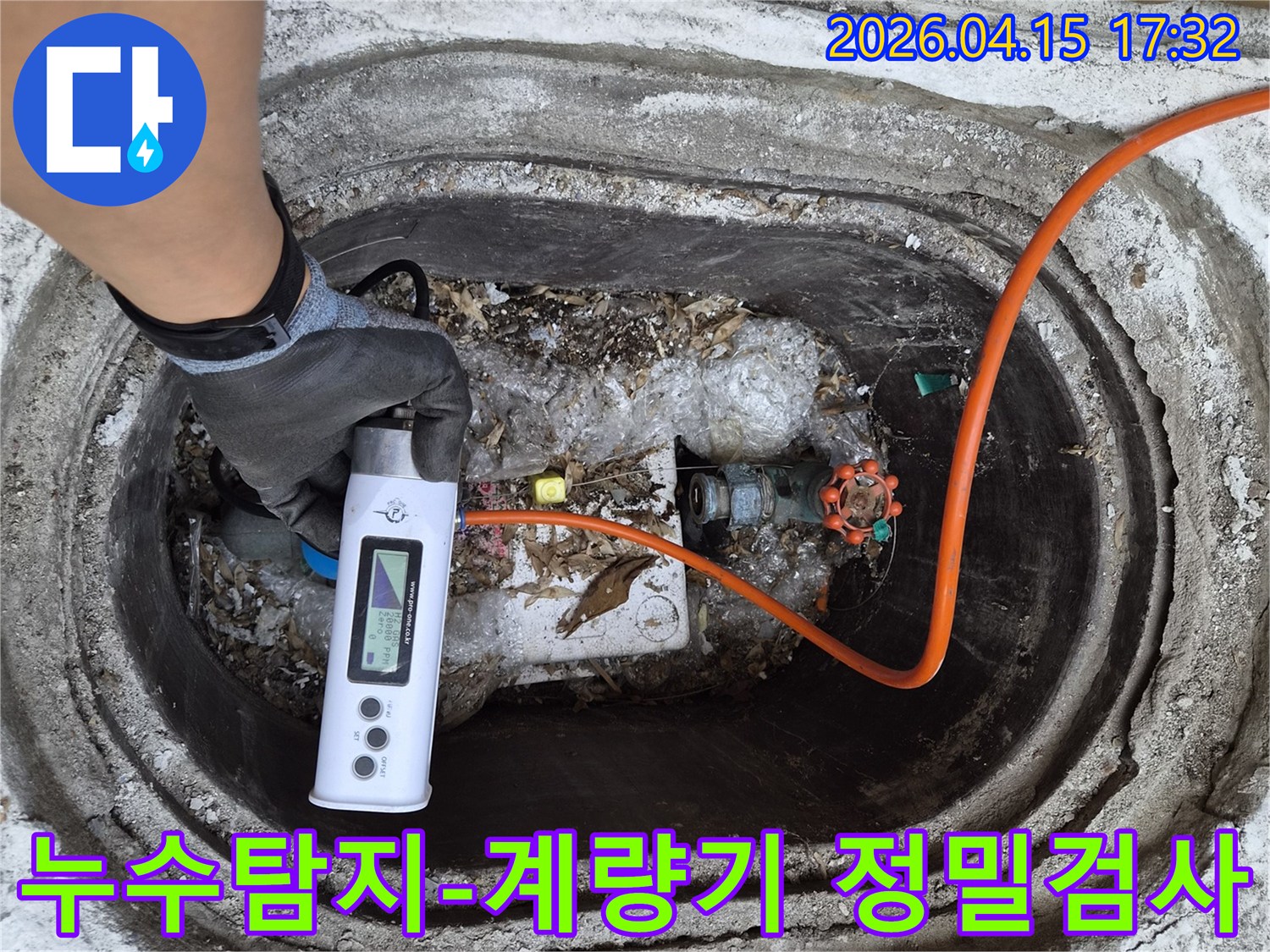 누수 엔지니어가-장갑을 끼고-누수 탐지 장비로-수도 계량기 박스를-점검하는 모습