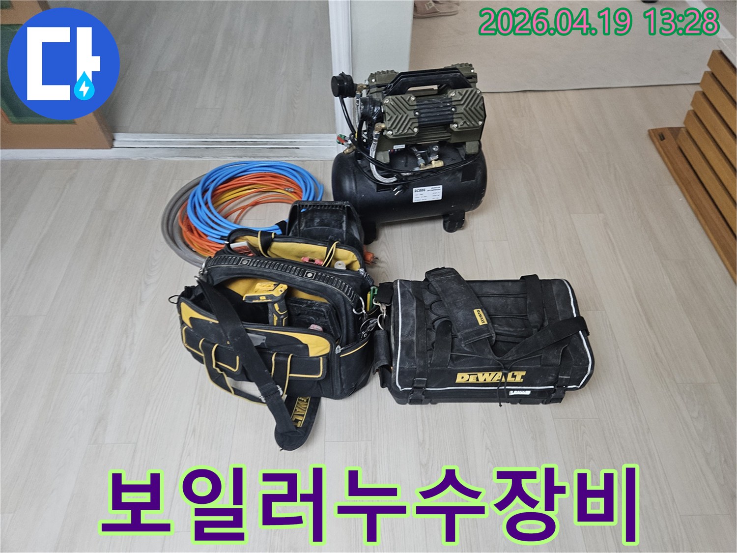 보일러 누수 탐지 및 수리를 위한-전문 장비들이 현장에 준비된 모습입니다-에어 컴프레서와-공구 가방-그리고 보일러 관련 배관 자재들이 보입니다.