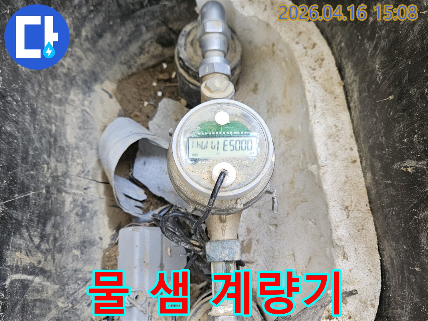 노후된 수도 계량기와- 그 주변의 흙먼지가- 누수 탐지의 어려움을- 보여주는 장면입니다.