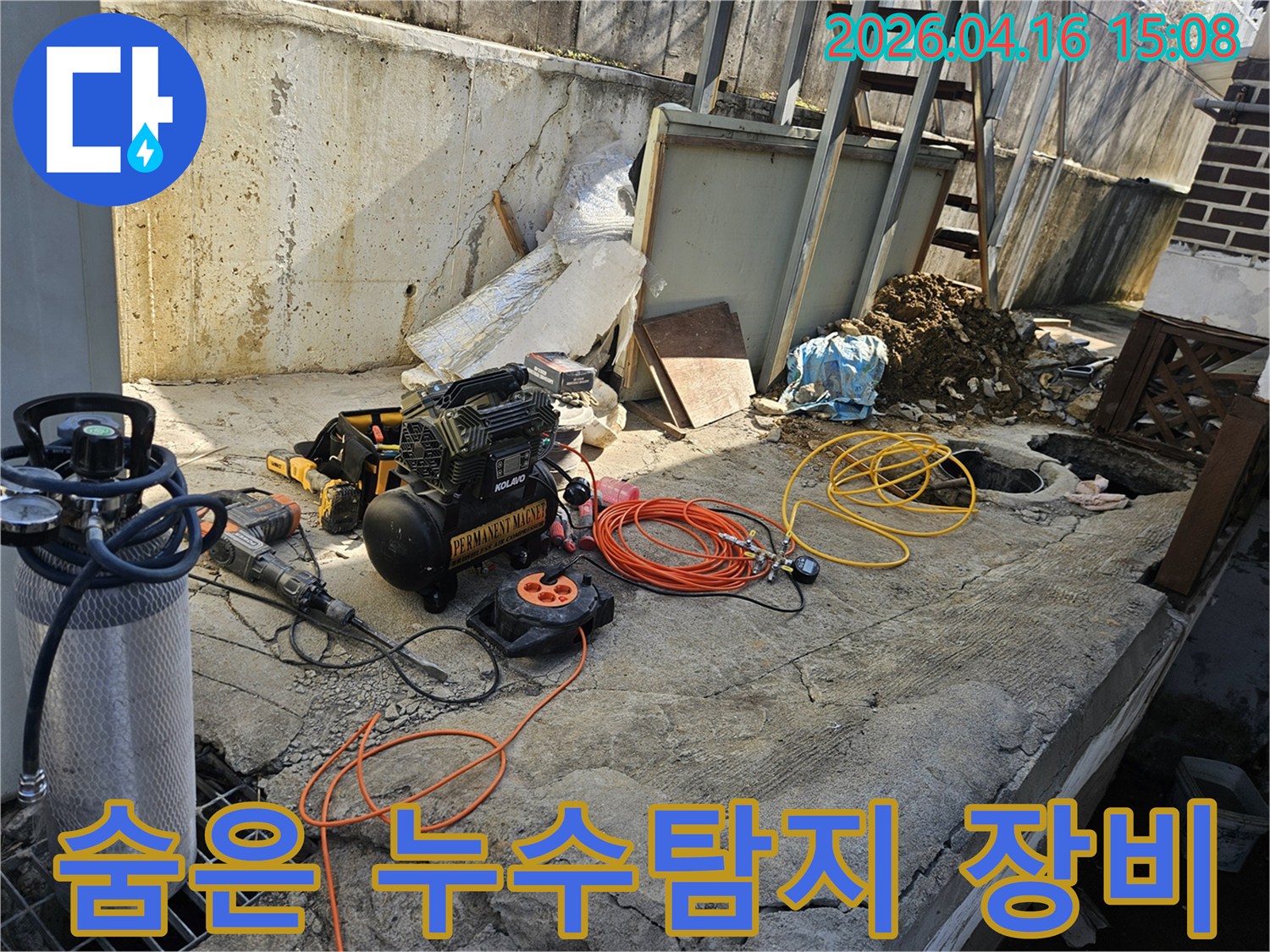 누수 공사를 위한-에어 콤프레셔-함마드릴-호스-전선릴 등-다양한 전문 장비들이-콘크리트 바닥 위에-정돈되어 있는-작업 준비 현장