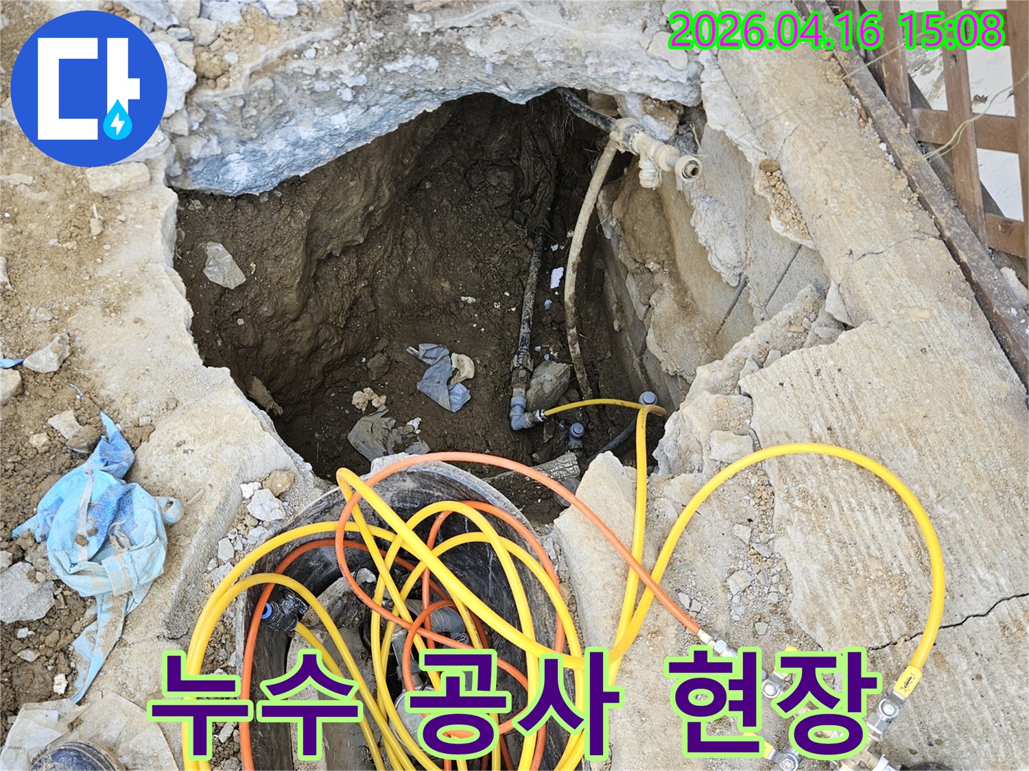 누수 지점을 찾아내고 배관을 수리하기 위해-땅을 파내고 전문 압력 테스트 장비를 설치하여-정밀하게 진단하는 작업 현장입니다.
