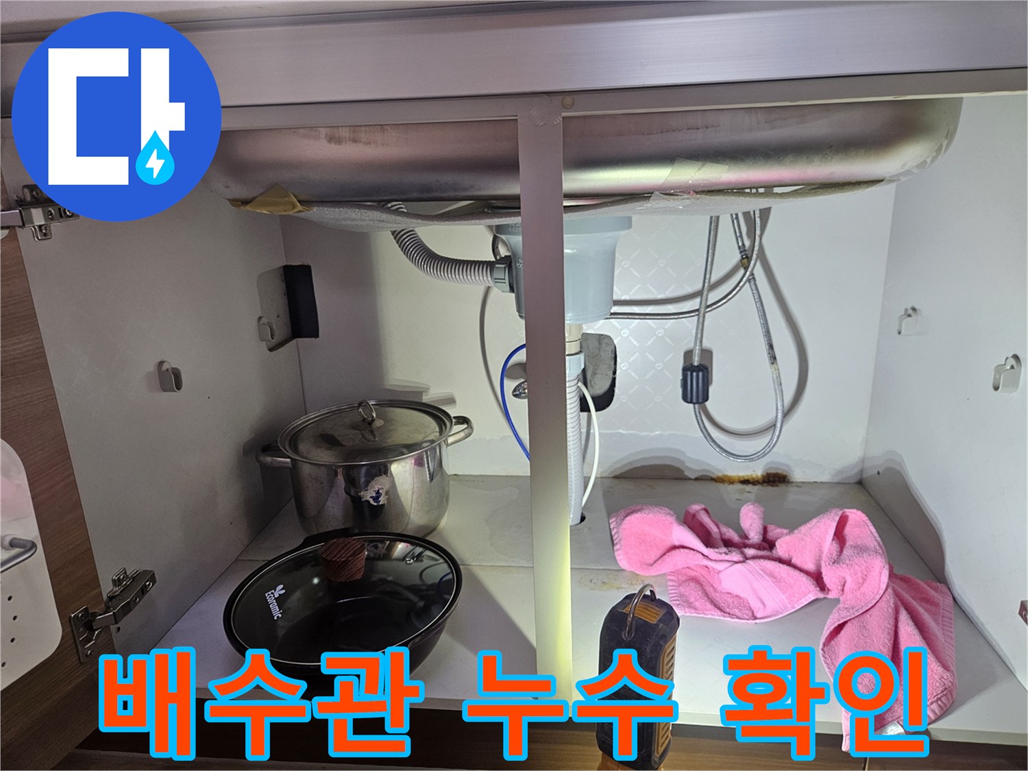 싱크대-아래-배수관에서-누수가-발생하여-바닥에-물기가-보이는-현장-사진입니다