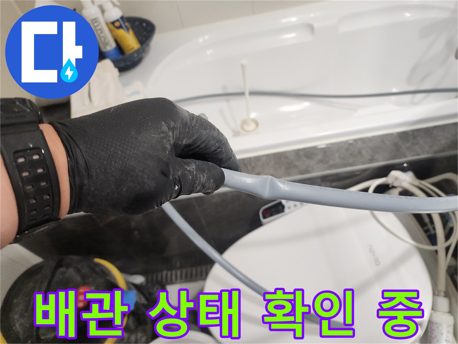 엔지니어가 배관의 연결 부위를 손으로 만지며 점검하고 있습니다.