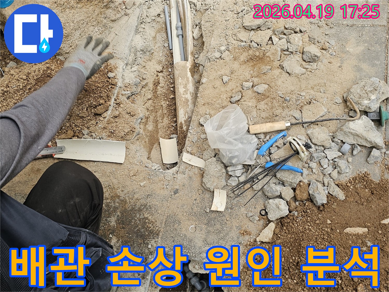 누수 공사 현장에서-바닥 파쇄 후-노출된 배관의 손상 원인을-전문가가 면밀히 분석하는 모습