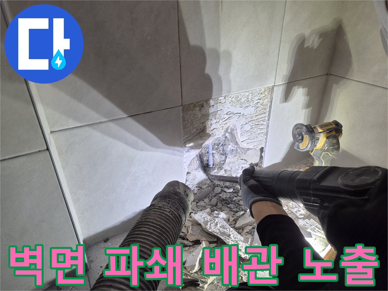 누수 발생 배관을 찾아내기 위해-벽면 타일과 콘크리트를 파쇄하는-전문가의 작업 모습입니다.