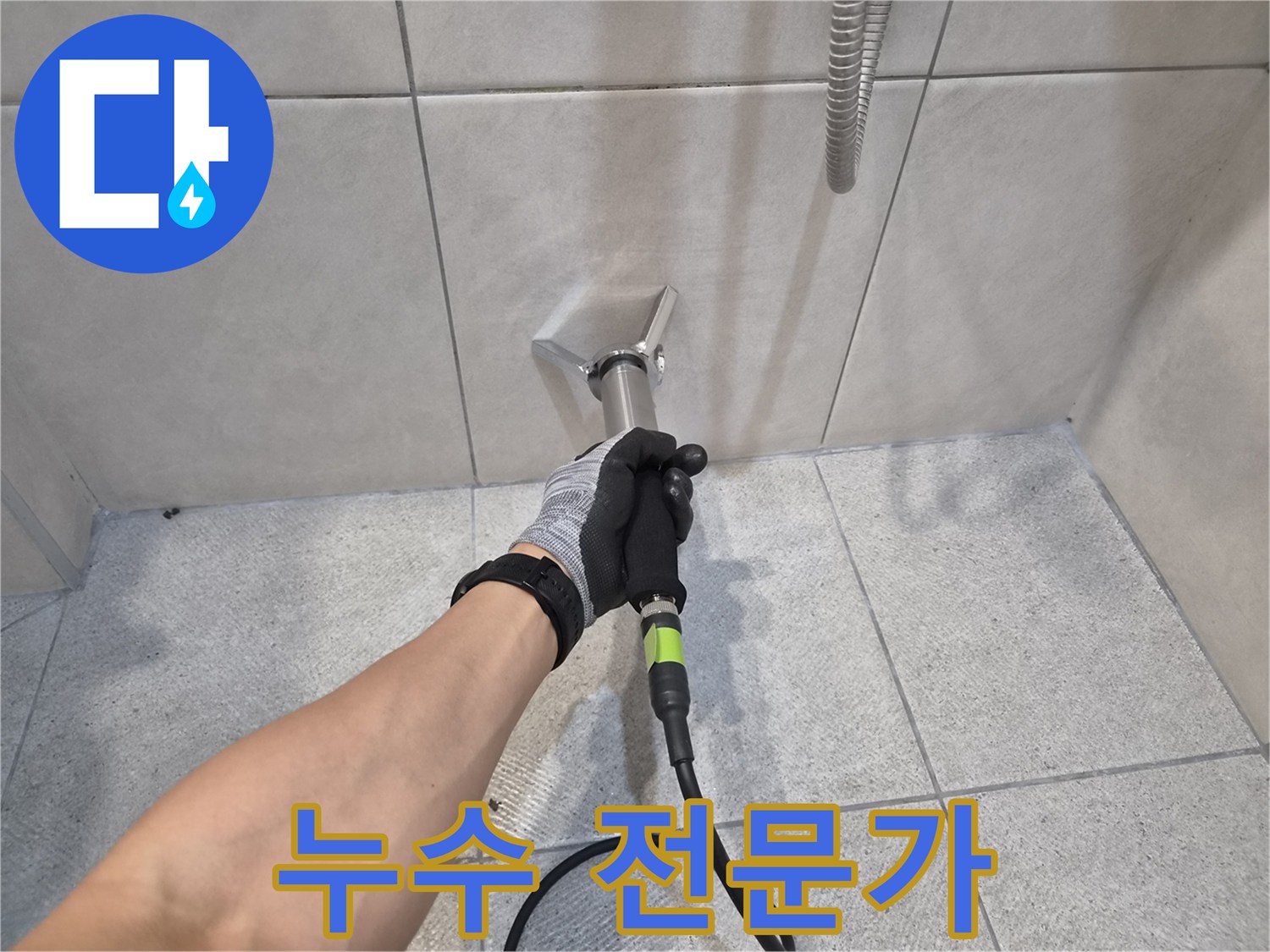 숙련된 누수 전문 엔지니어가-구터만 청음기를 사용하여-타일 벽면의-누수 지점을-정확하게 탐지하는-모습을 담고 있습니다