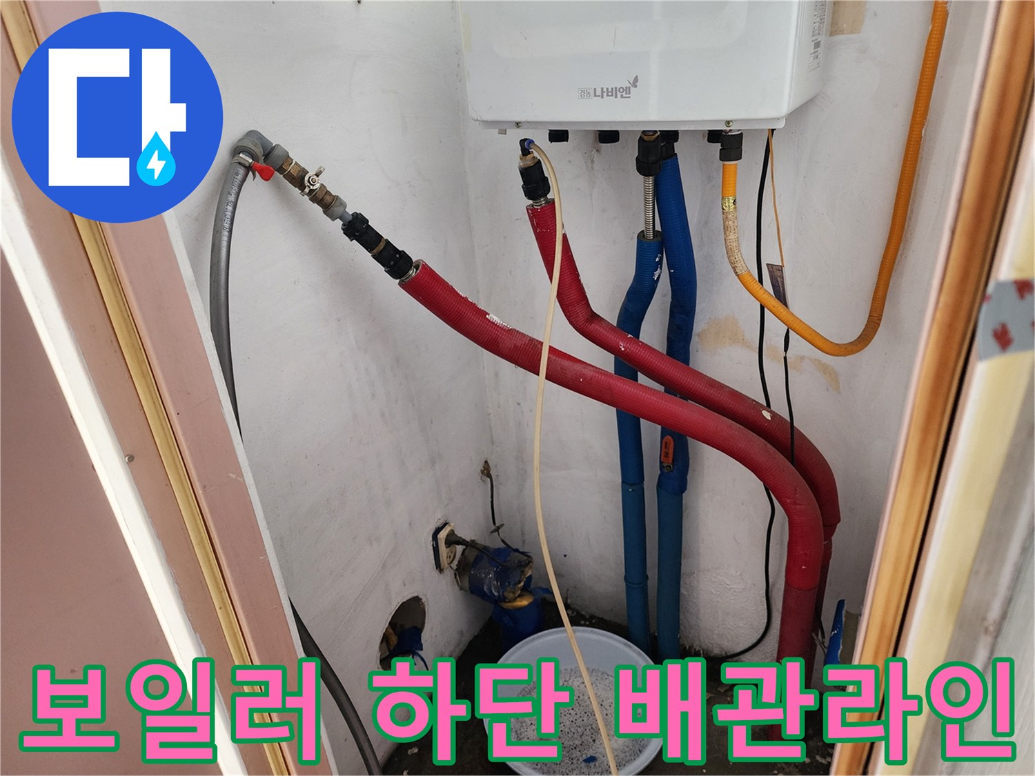보일러 아래에 연결된 빨간색과 파란색의 급수 및 온수 배관