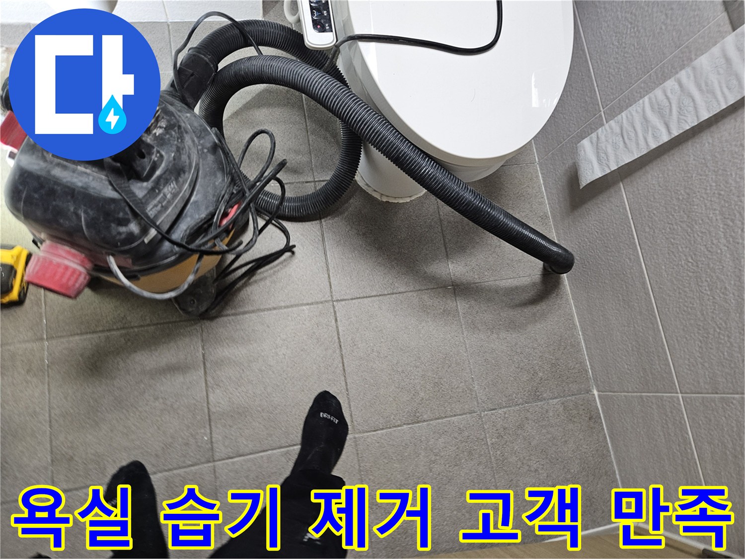 오산시 고객 댁 욕실에서-누수 엔지니어가-변기 주변의 습기를-습식 청소기로 제거하며-고객 만족을 위해 최선을 다하는 모습