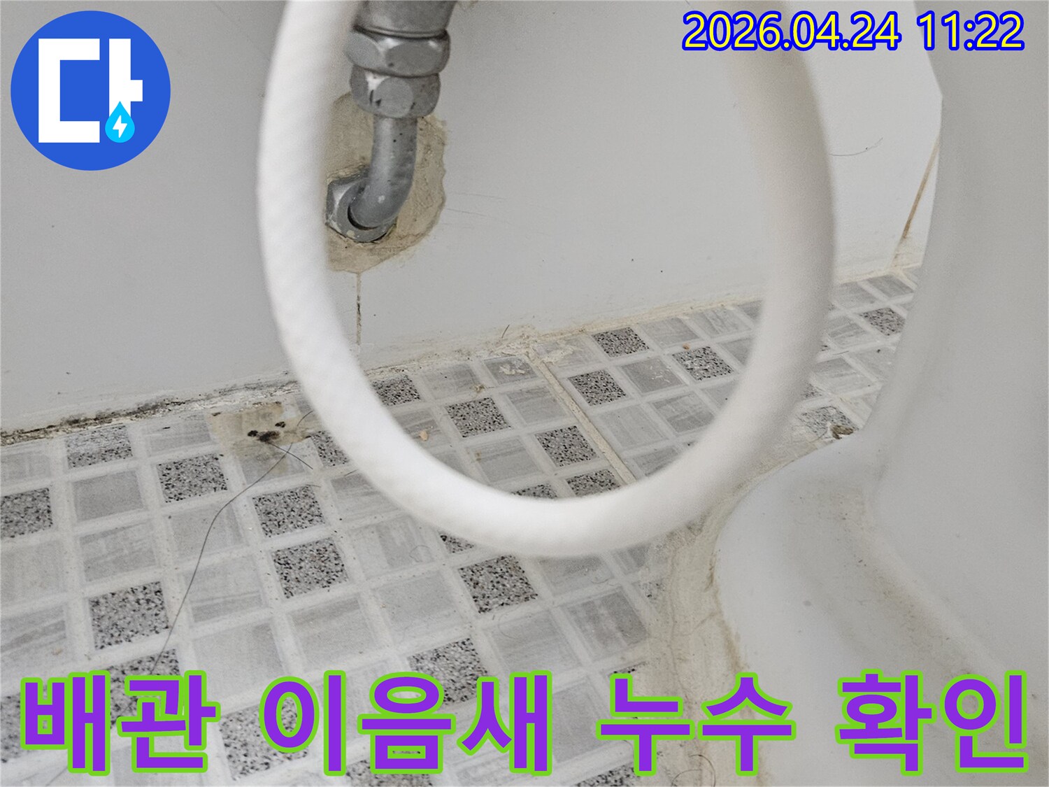 욕실 벽면의-수도 배관 이음새 부분에서-발생한 누수 흔적을-근접 촬영한 사진입니다.