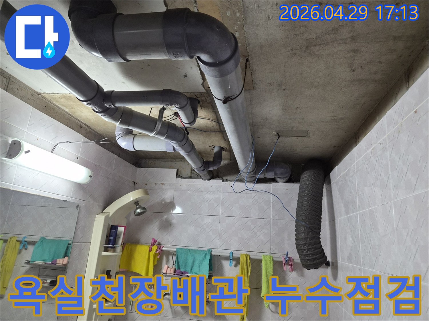욕실 천장 배관에서 발생한 누수 문제를 해결하기 위해-전문가가 점검하는 모습입니다
