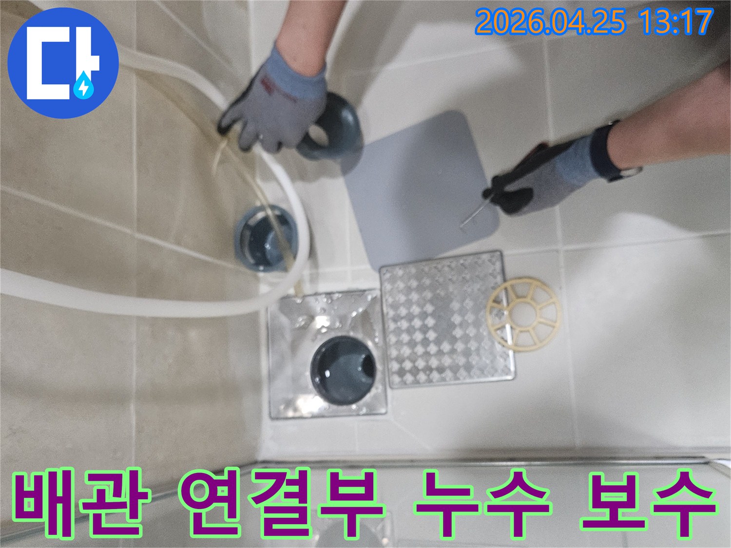 아파트 배관 연결 부위에서 발생한-누수를 확인하고 보수하기 위해-전문가가 점검하는 장면입니다.
