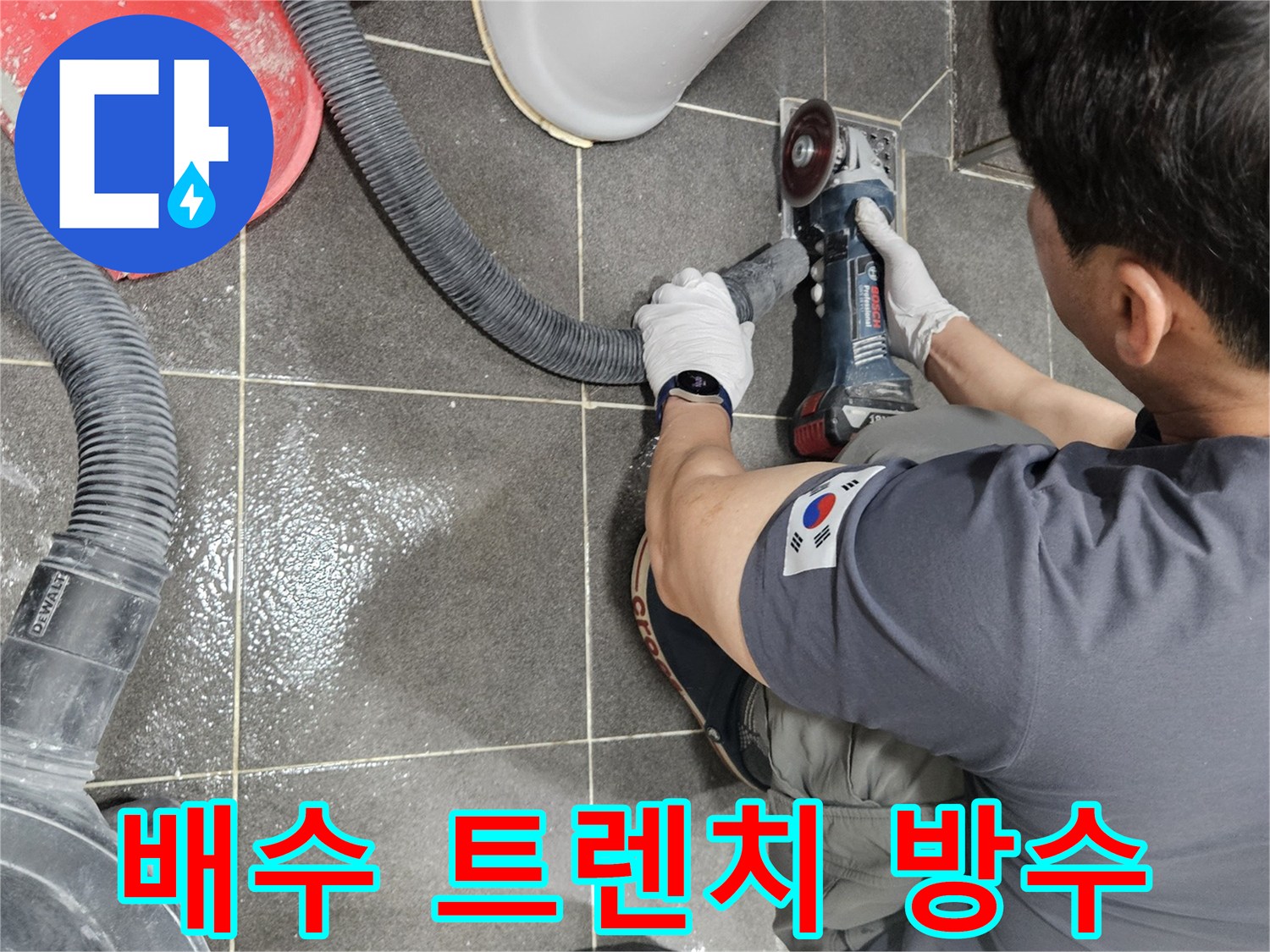 숙련된 기술자가 욕실 유가 주변 타일을-그라인더로 컷팅하여 누수 원인을 찾아내고 있습니다.