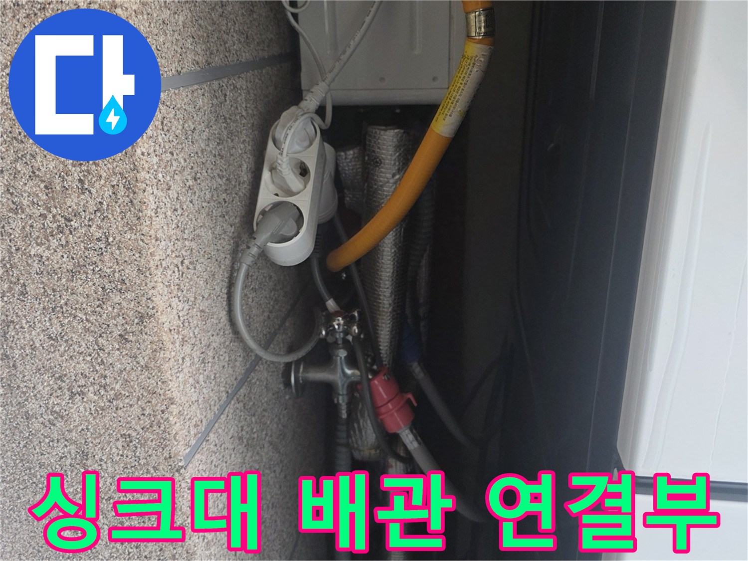 노란색 배수 호스와 은색 금속 부품의 결합 상태를 촬영한 모습입니다