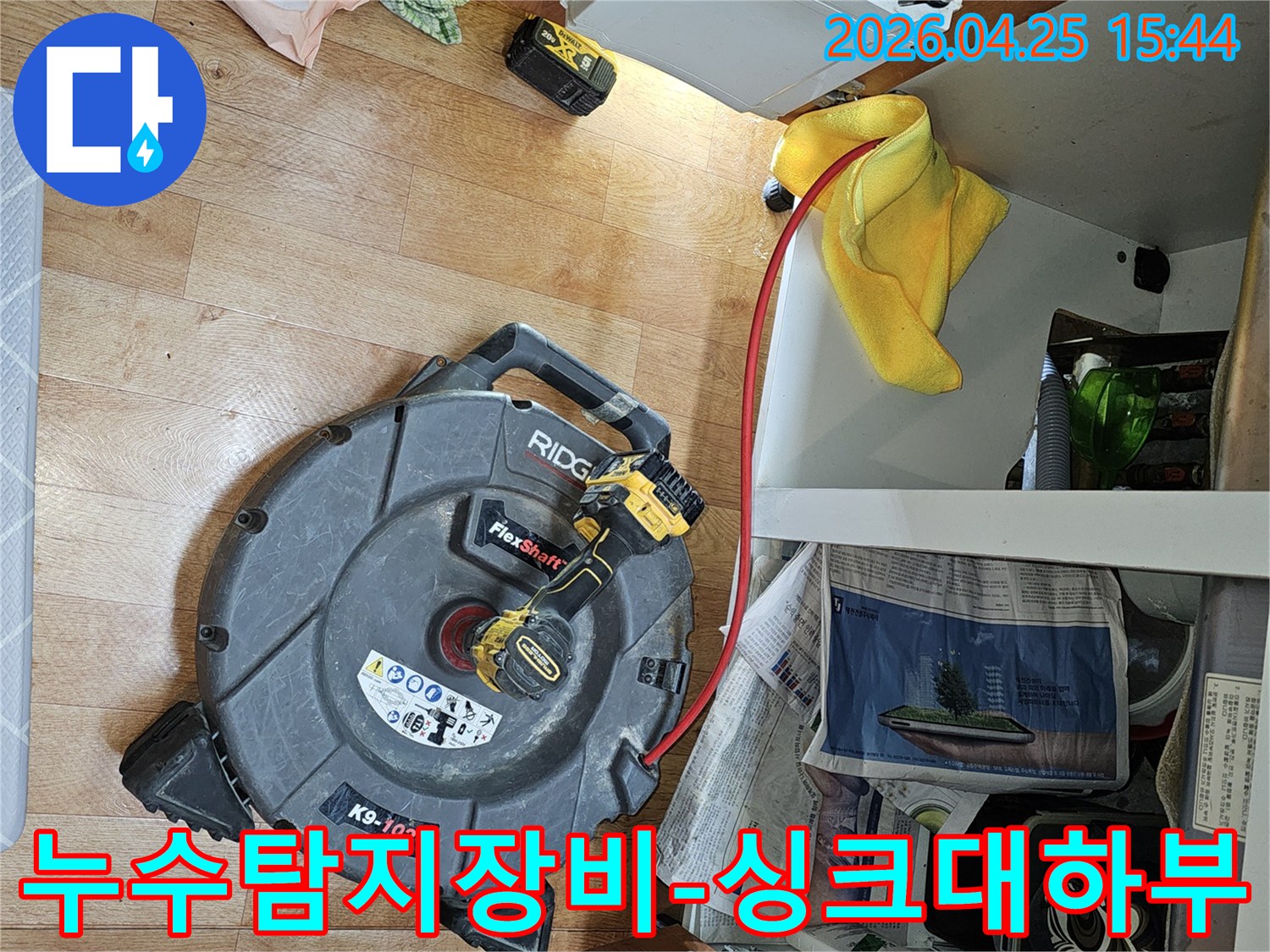 싱크대 하부에서-누수 탐지 및 배관 청소를 위해-전문 장비를 사용해-작업하는 모습