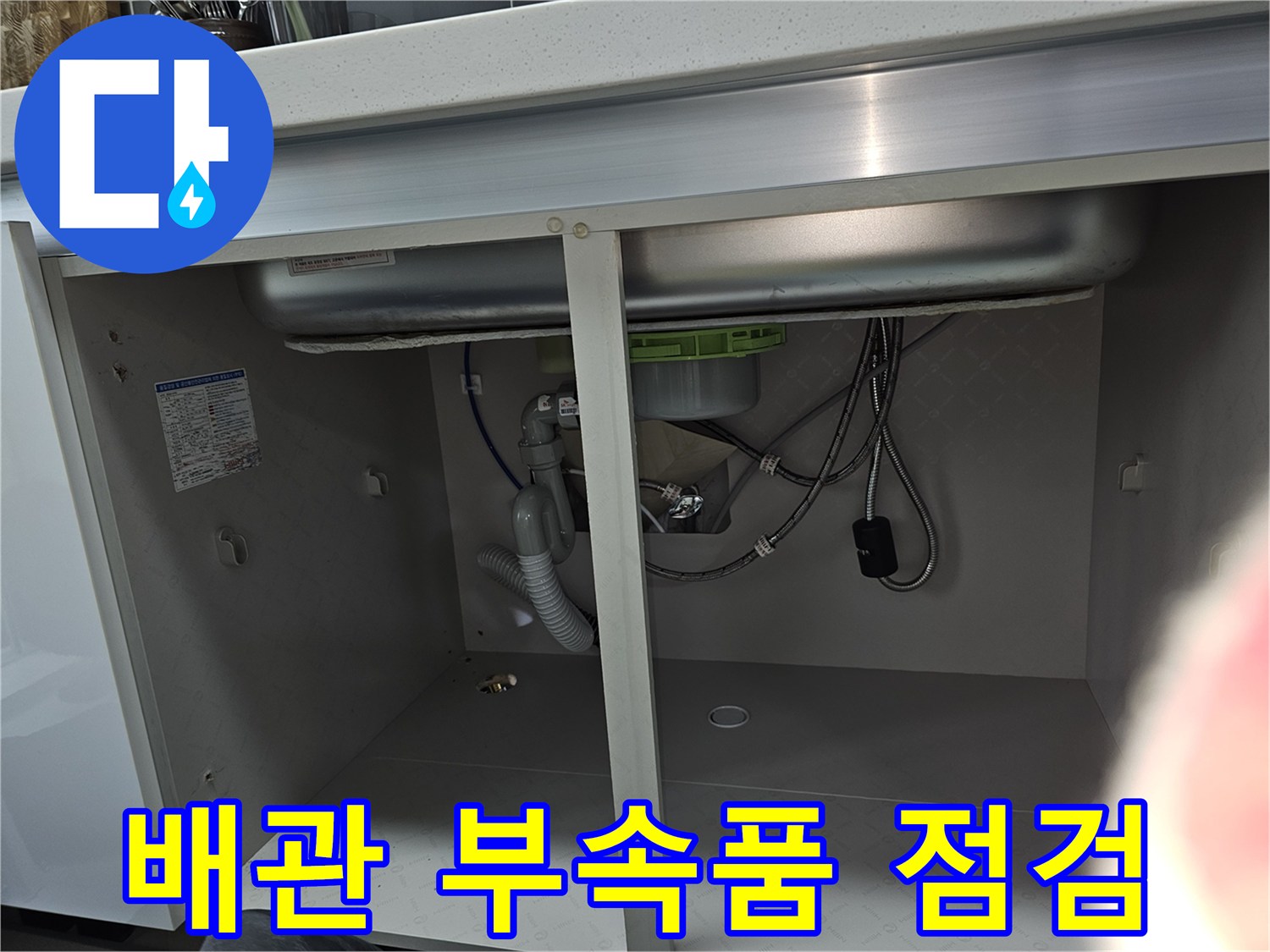 싱크대 하부의 배관을 연결하는 다양한 부속품들을 보여주는 이미지로-각 부속품의 상태와 누수 여부를 정밀하게 점검하고 있습니다.