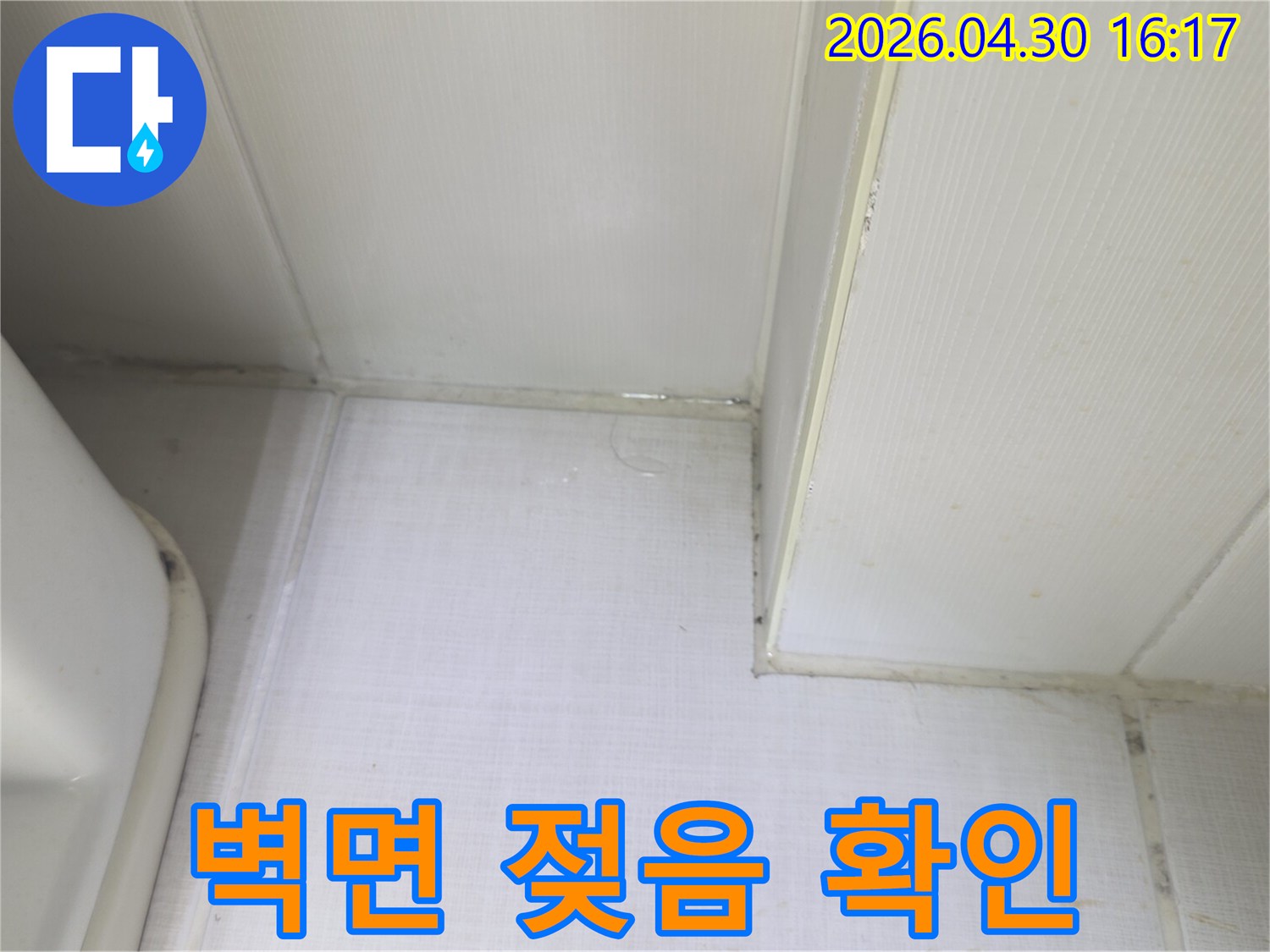 벽과 천장 사이에서 물이 새어 나와-벽면이 축축하게 젖어있는 상태를 보여주는-누수 발생 현장의 증거 사진