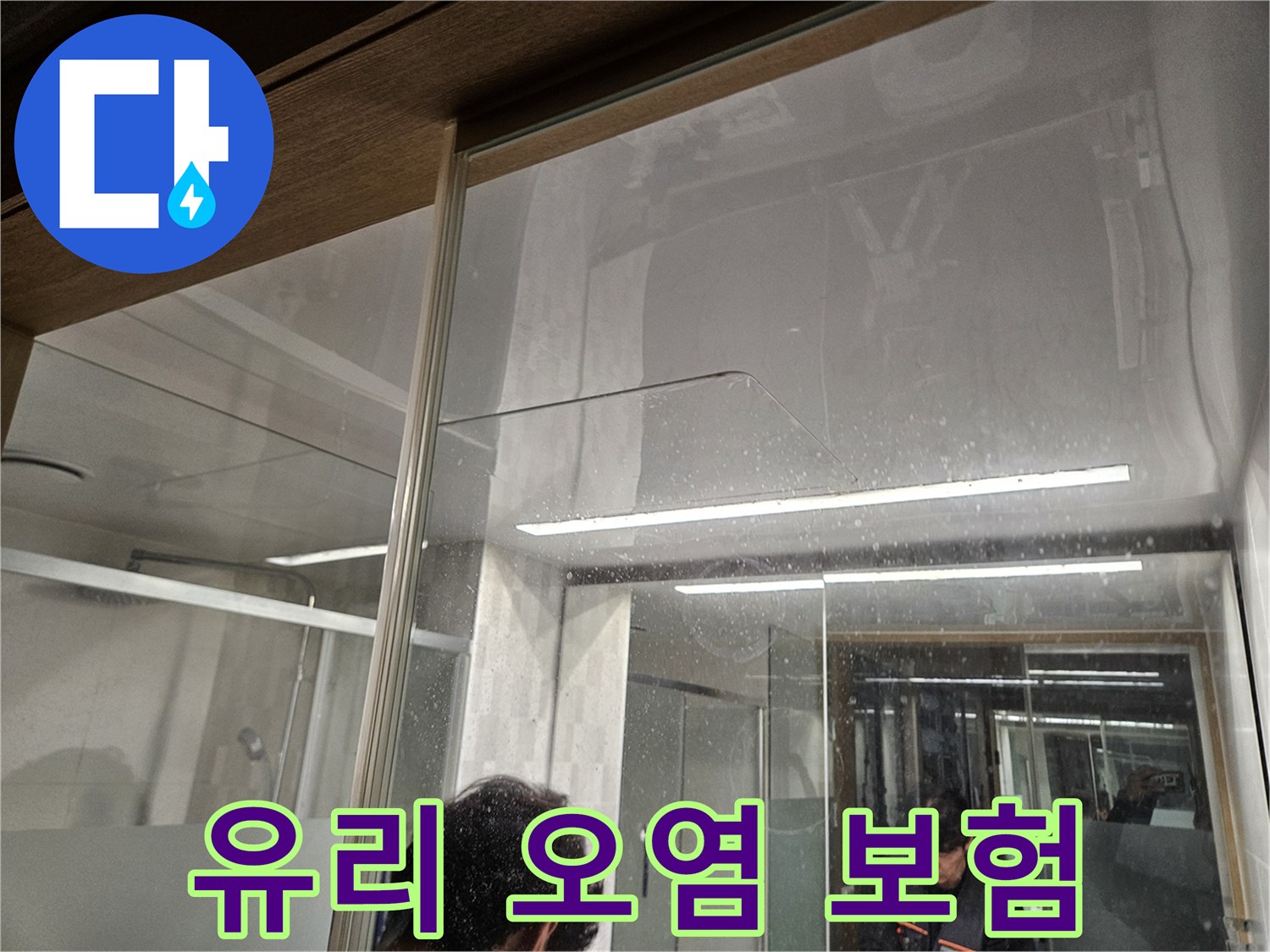 유리-벽면에-남은-물-자국과-오염-흔적-누수-전문가가-누수-보험-처리를-위해-현장을-확인하는-모습