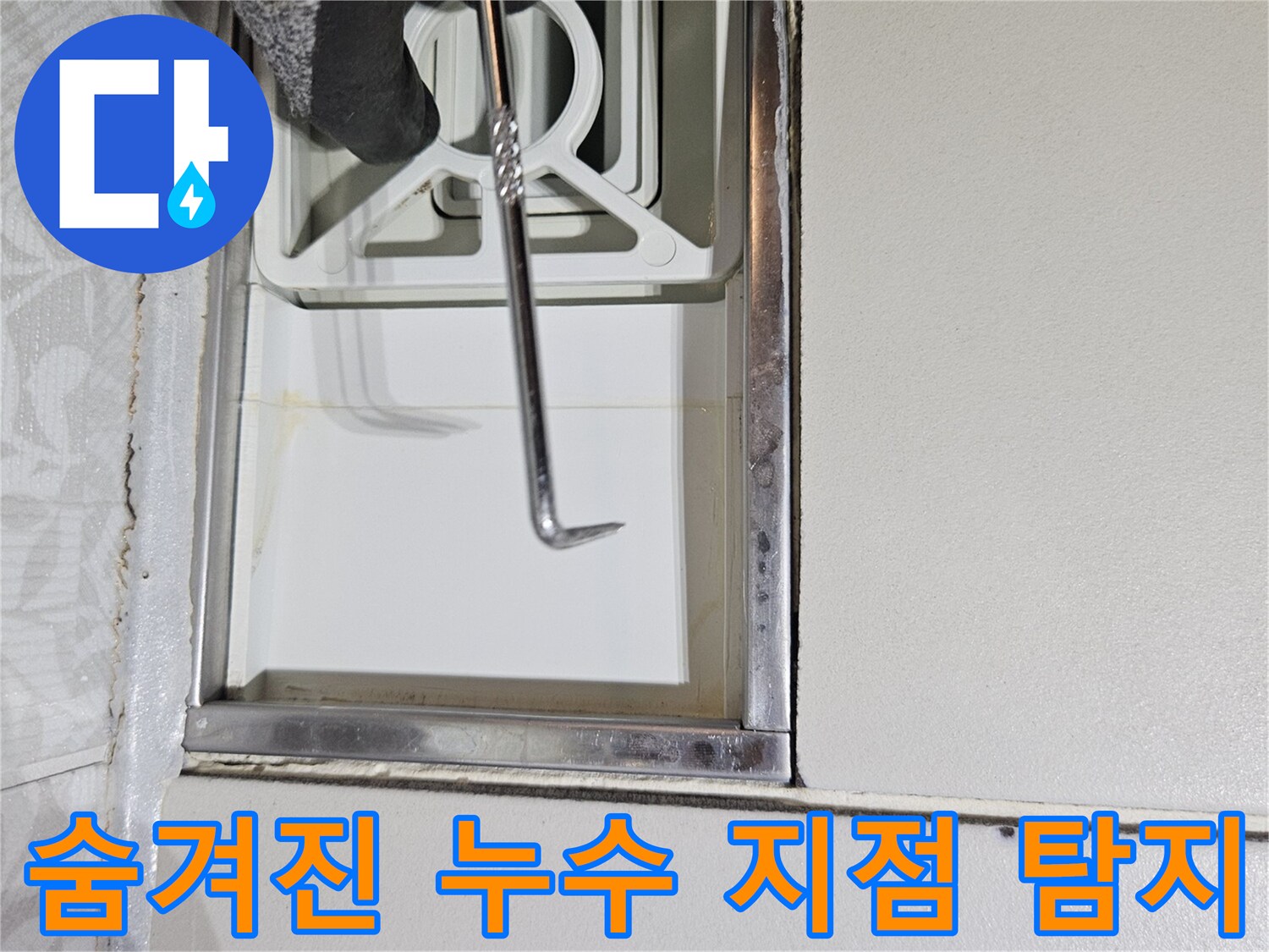 전문 누수 탐지사가-육안으로 확인하기 어려운-벽면 틈새를-특수 도구로-정밀하게-조사하는 장면입니다