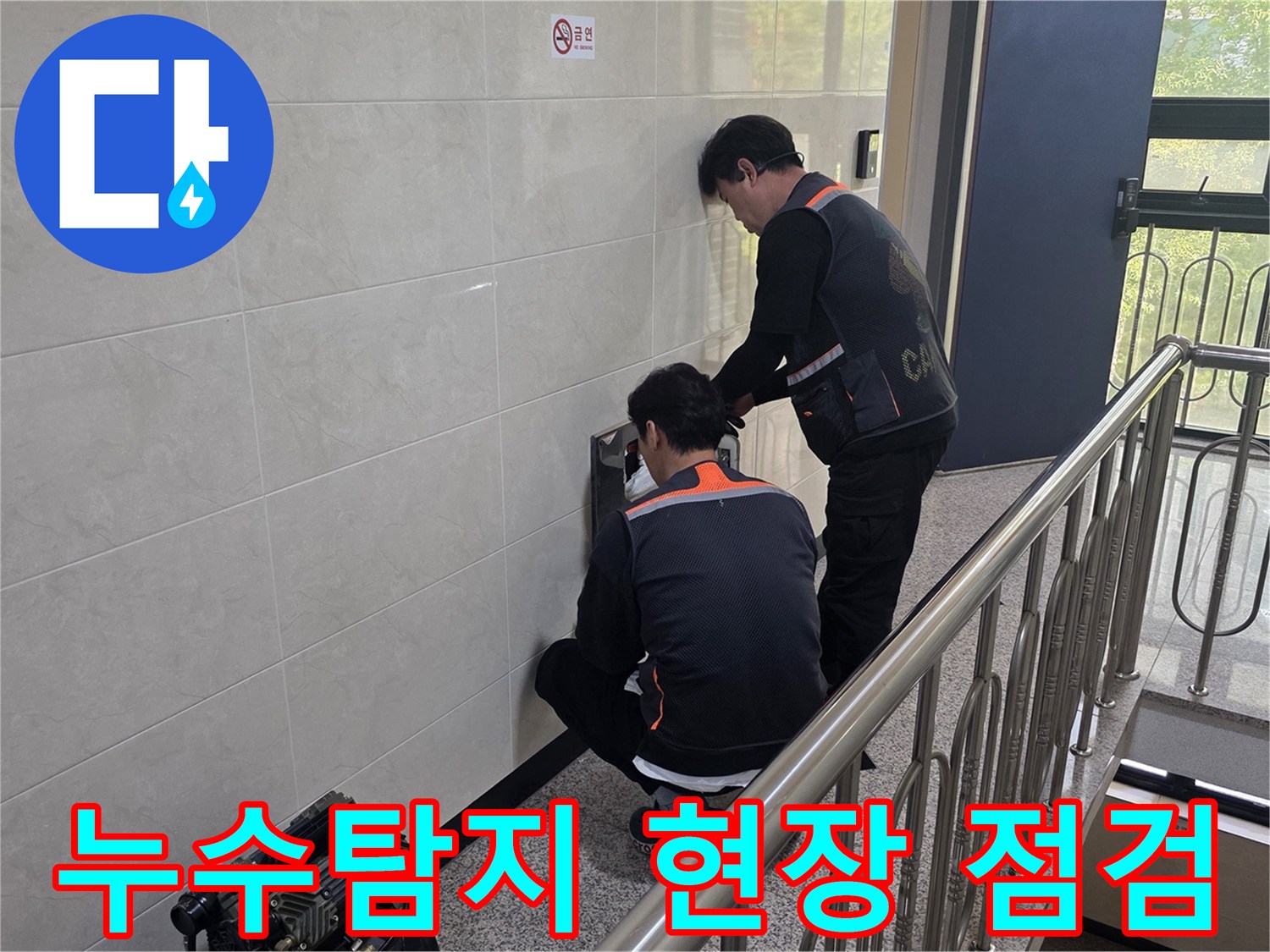 두 명의 엔지니어가 건물 내부 벽면의 누수 지점을 정밀하게 점검하고 있습니다-누수 원인 파악을 위한 초기 단계입니다.